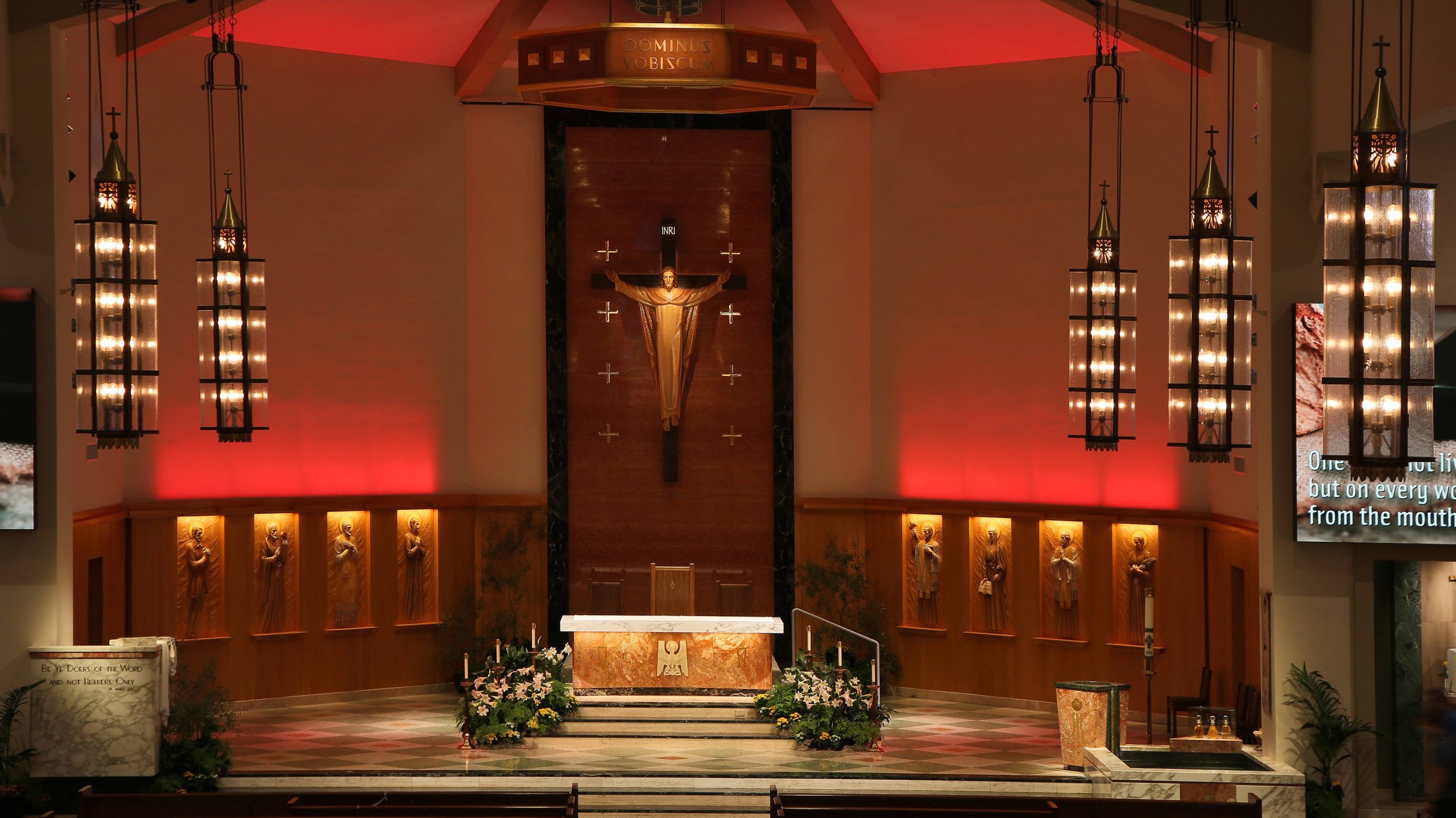 A medium front-on shot of the altar with red lighting in the American Martyrs Church, a Southern California Religious Architecture Project by Pica + Sullivan Architects.
