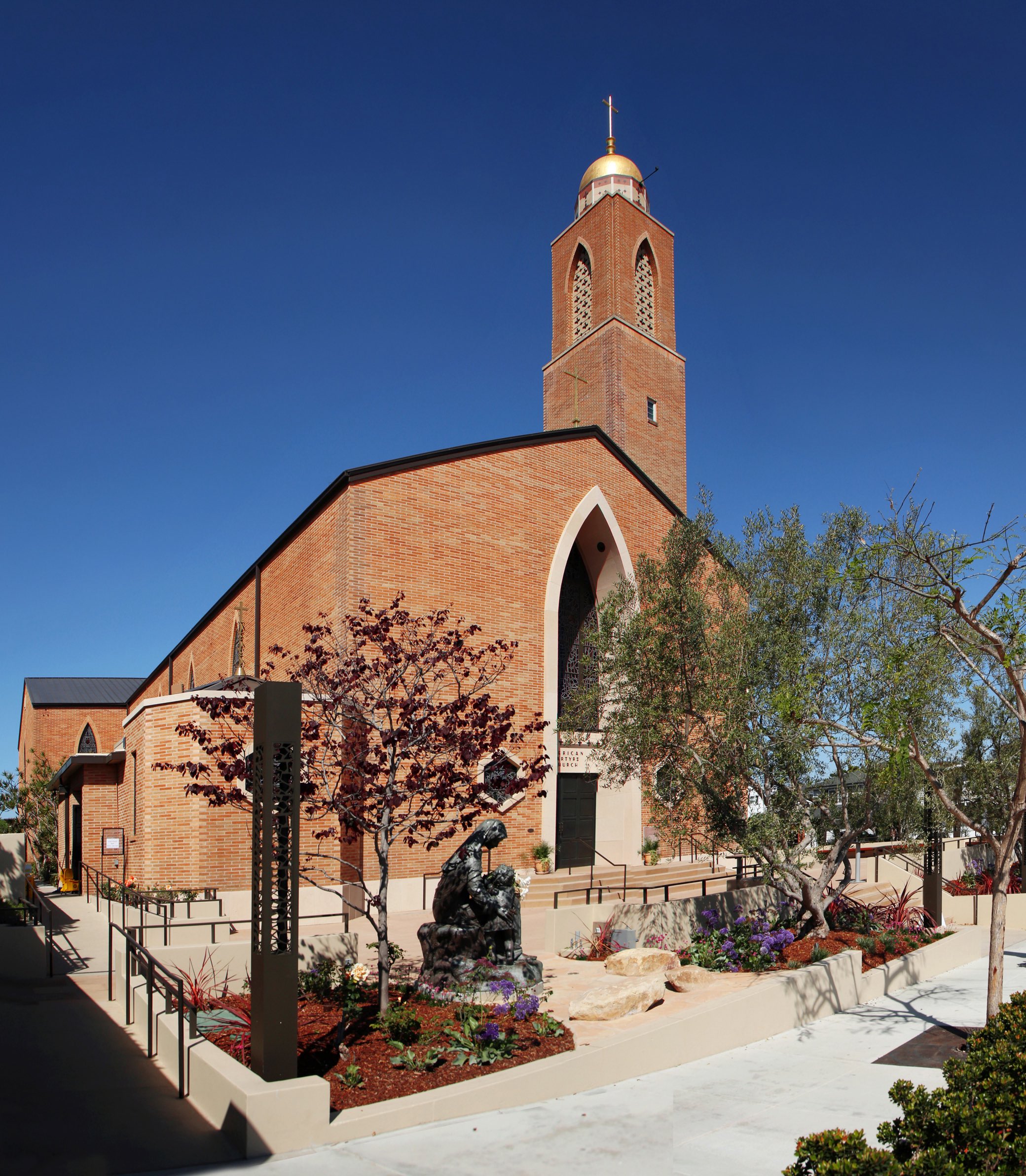 Exterior shot, including garden and bronze sculpture, of the American Martyrs Church, a Southern California Religious Architecture Project by Pica + Sullivan Architects.