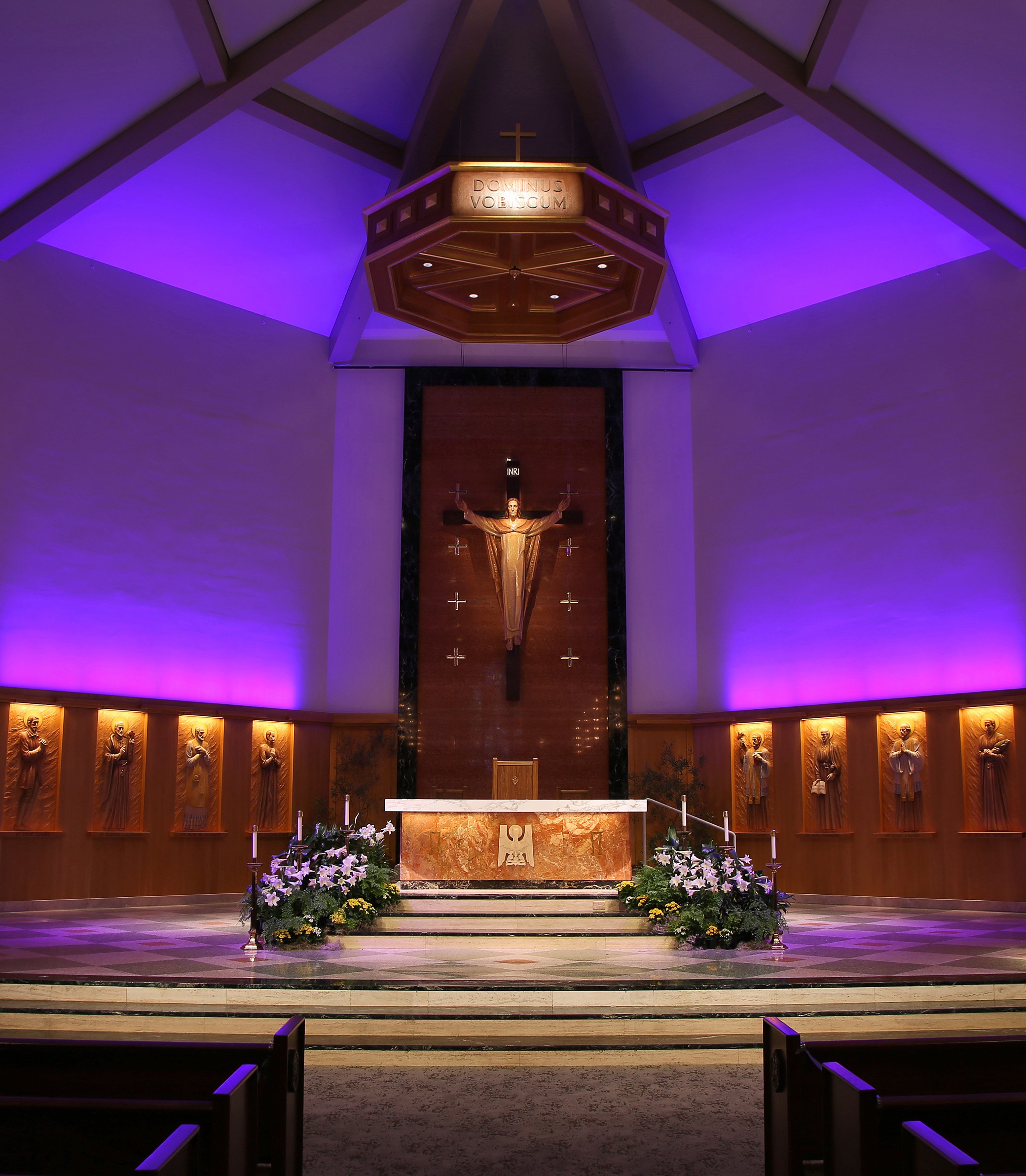 A medium front-on shot of the altar with purple lighting in the American Martyrs Church, a Southern California Religious Architecture Project by Pica + Sullivan Architects.