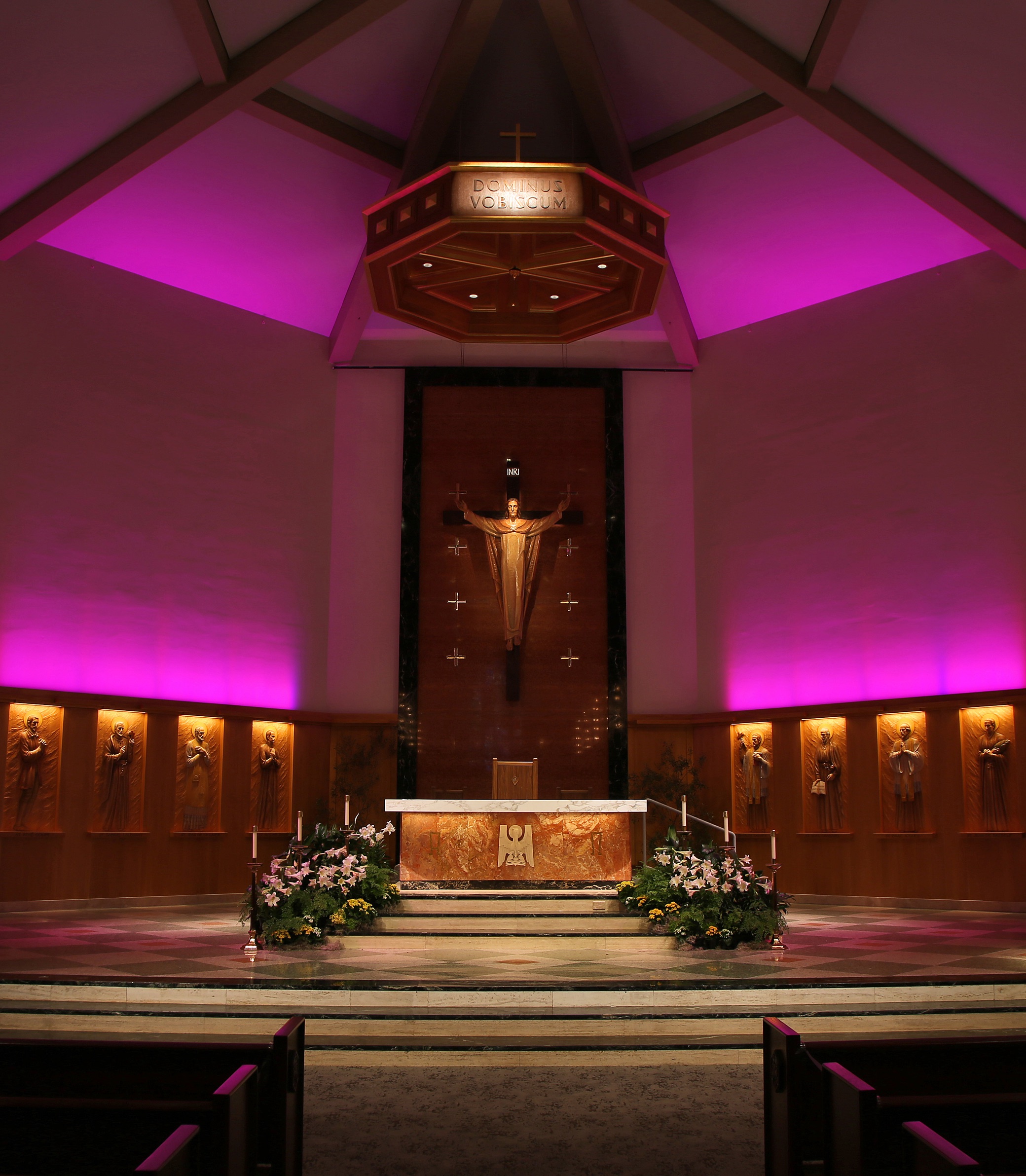 A medium front-on shot of the altar with magenta lighting in the American Martyrs Church, a Southern California Religious Architecture Project by Pica + Sullivan Architects.