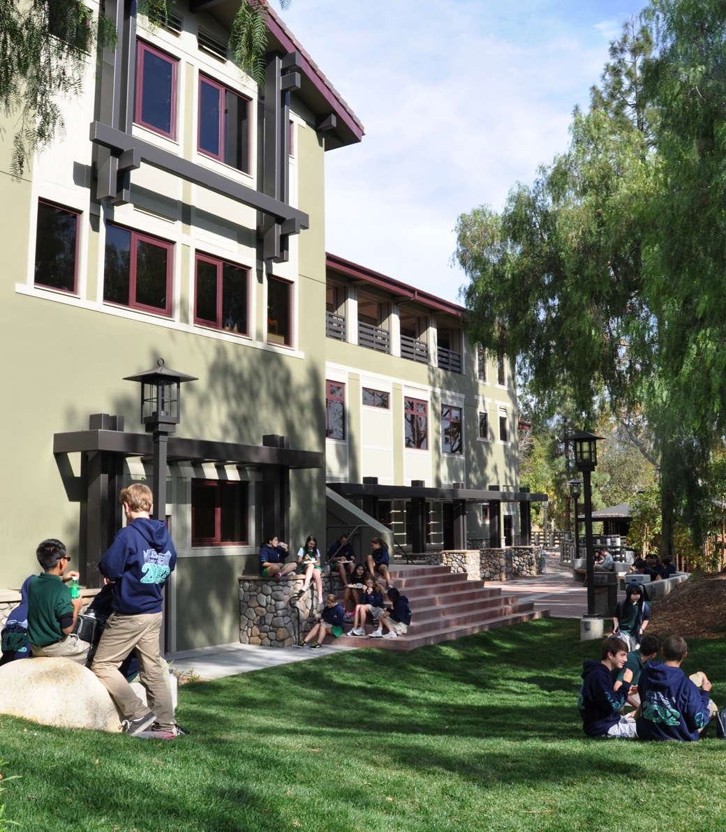 Students sit on a grassy area outside the Chandler School in Pasadena, an educational architecture project in Southern California.