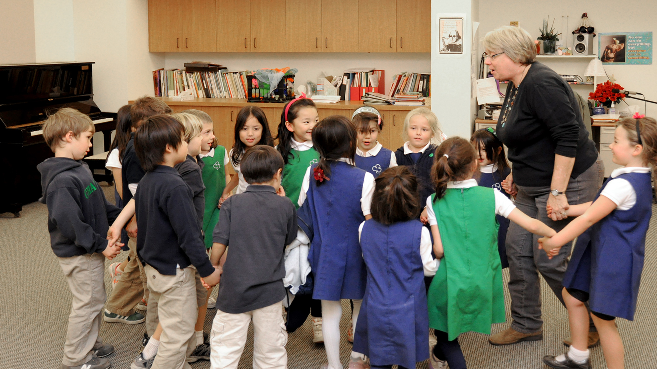 A teacher leads younger students in a circle at the Chandler School in Pasadena, an educational architecture project in Southern California.