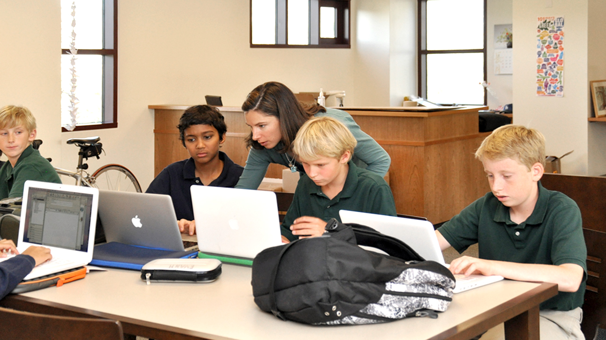 A teacher helps two students with work on their laptops in a classroom at the new middle school at the Chandler School in Pasadena, an educational architecture project in Southern California.