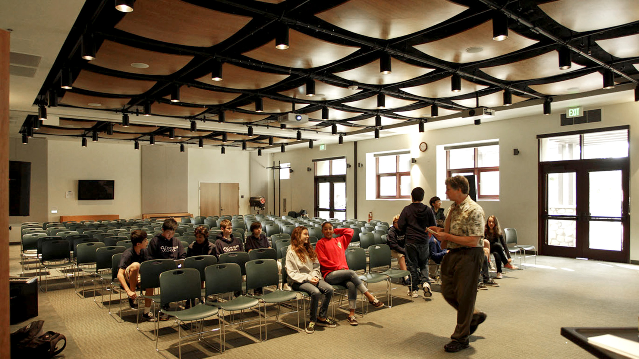 A teacher lectures a handful of students in an assembly room the Chandler School in Pasadena, an educational architecture project in Southern California.