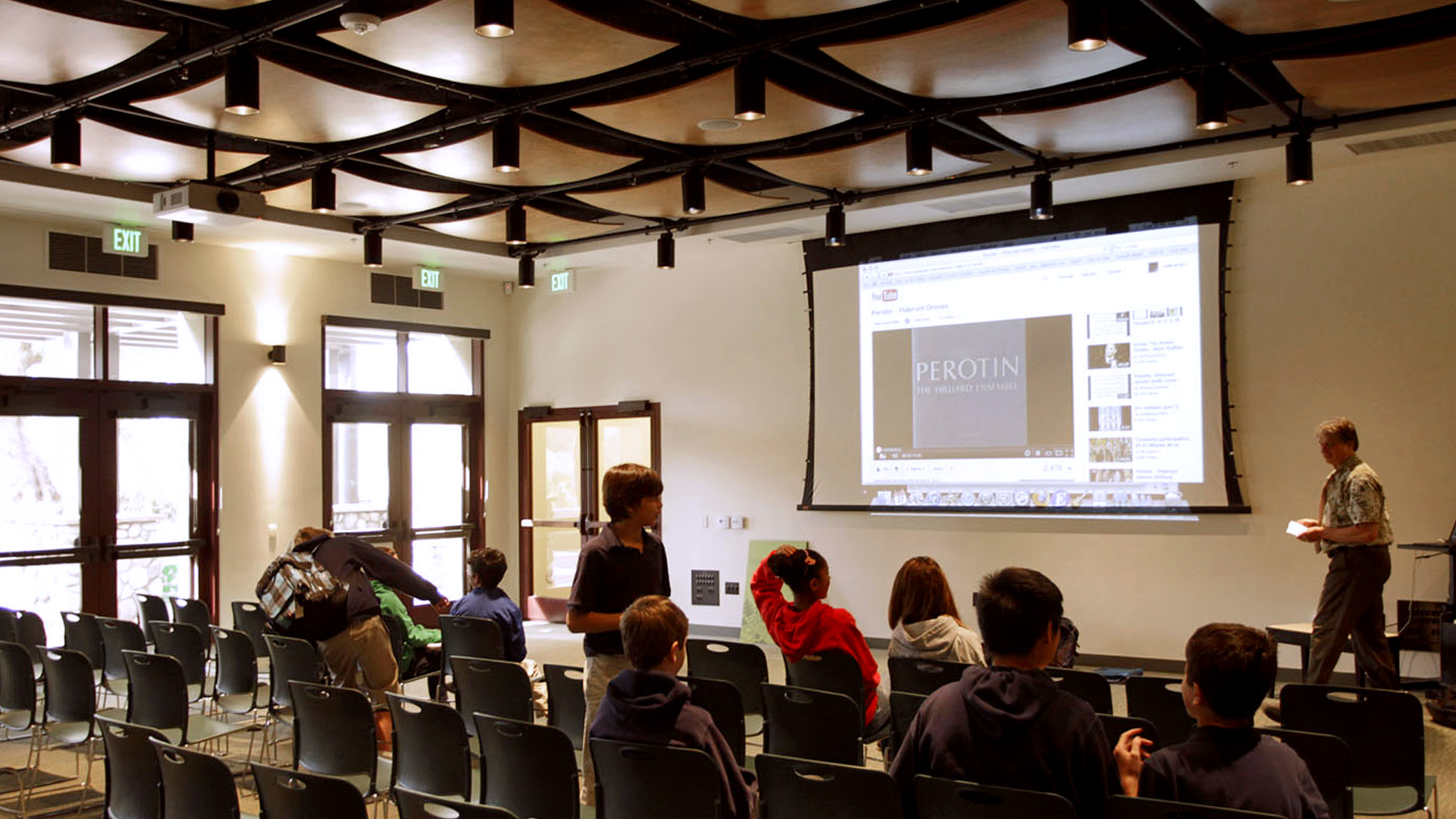 Students watch a YouTube video and listen to a teacher lecture at the Chandler School in Pasadena, an educational architecture project in Southern California.