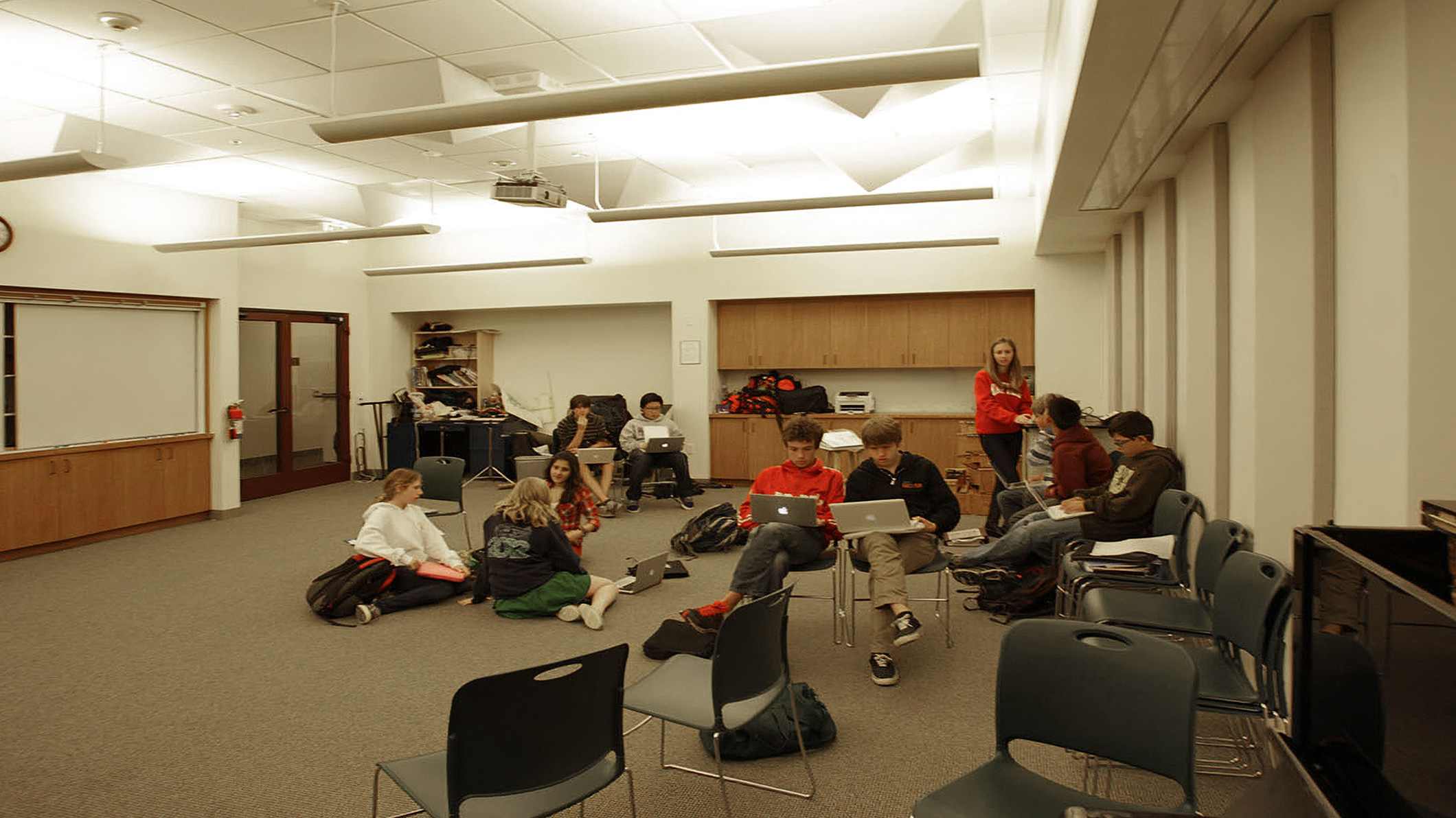 Students work and talk in a room at the Chandler School in Pasadena, an educational architecture project in Southern California.