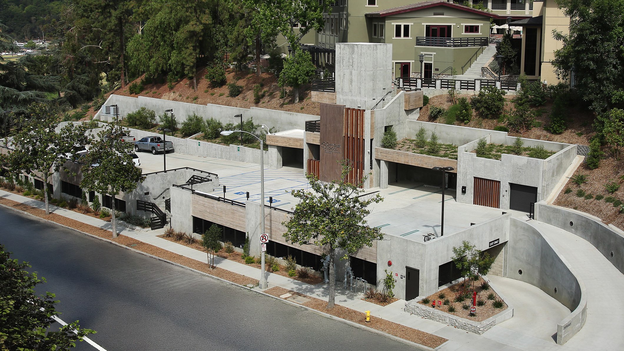 High-angle view of the new, multi-level parking structure at Chandler School in Pasadena, the buildings of the school visible on the hill behind the parking structure.