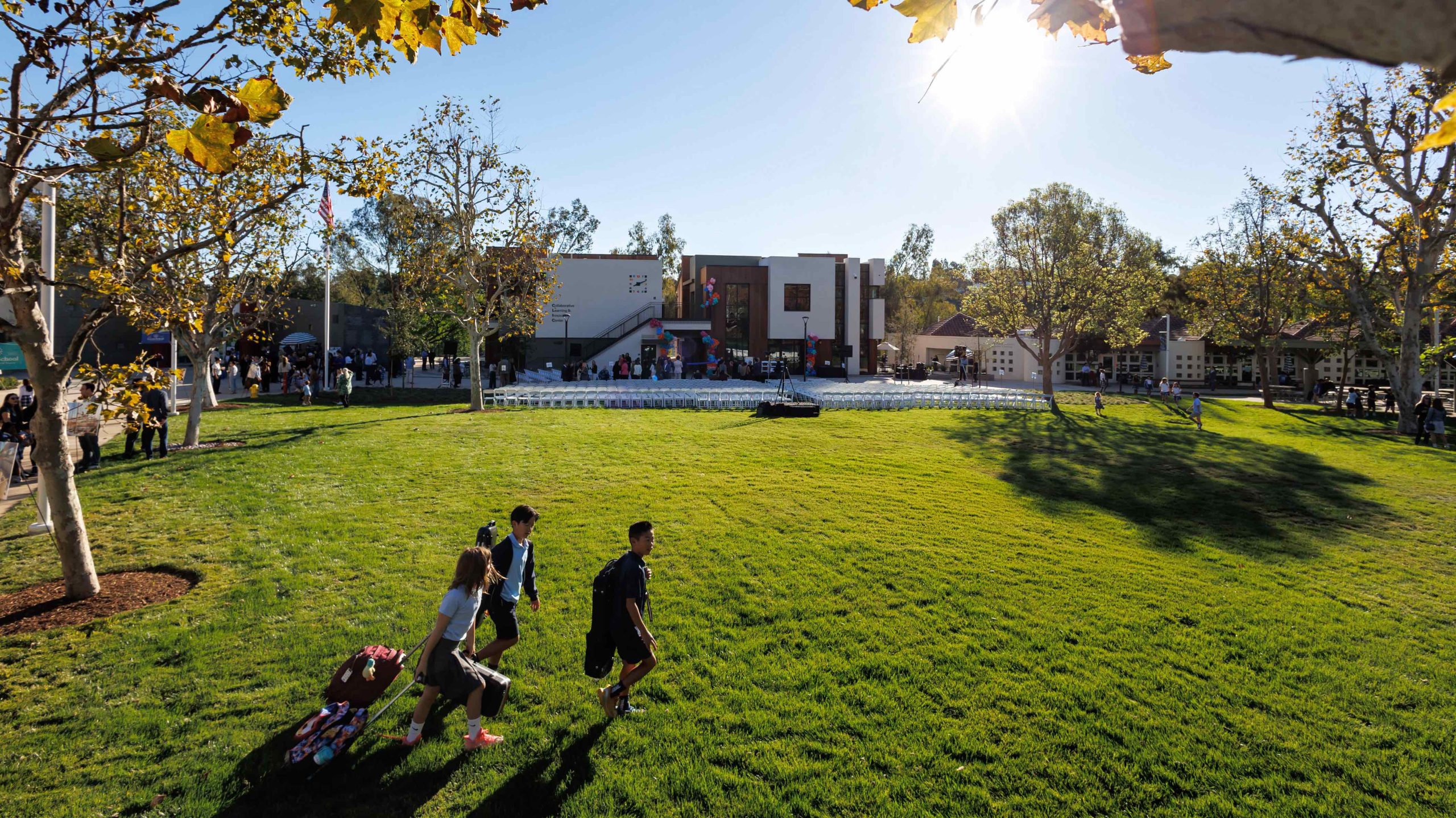 Three students walking across the lawn at the Collaborative Learning and Innovation Center, a Los Angeles educational architectural project by Pica + Sullivan Architects.