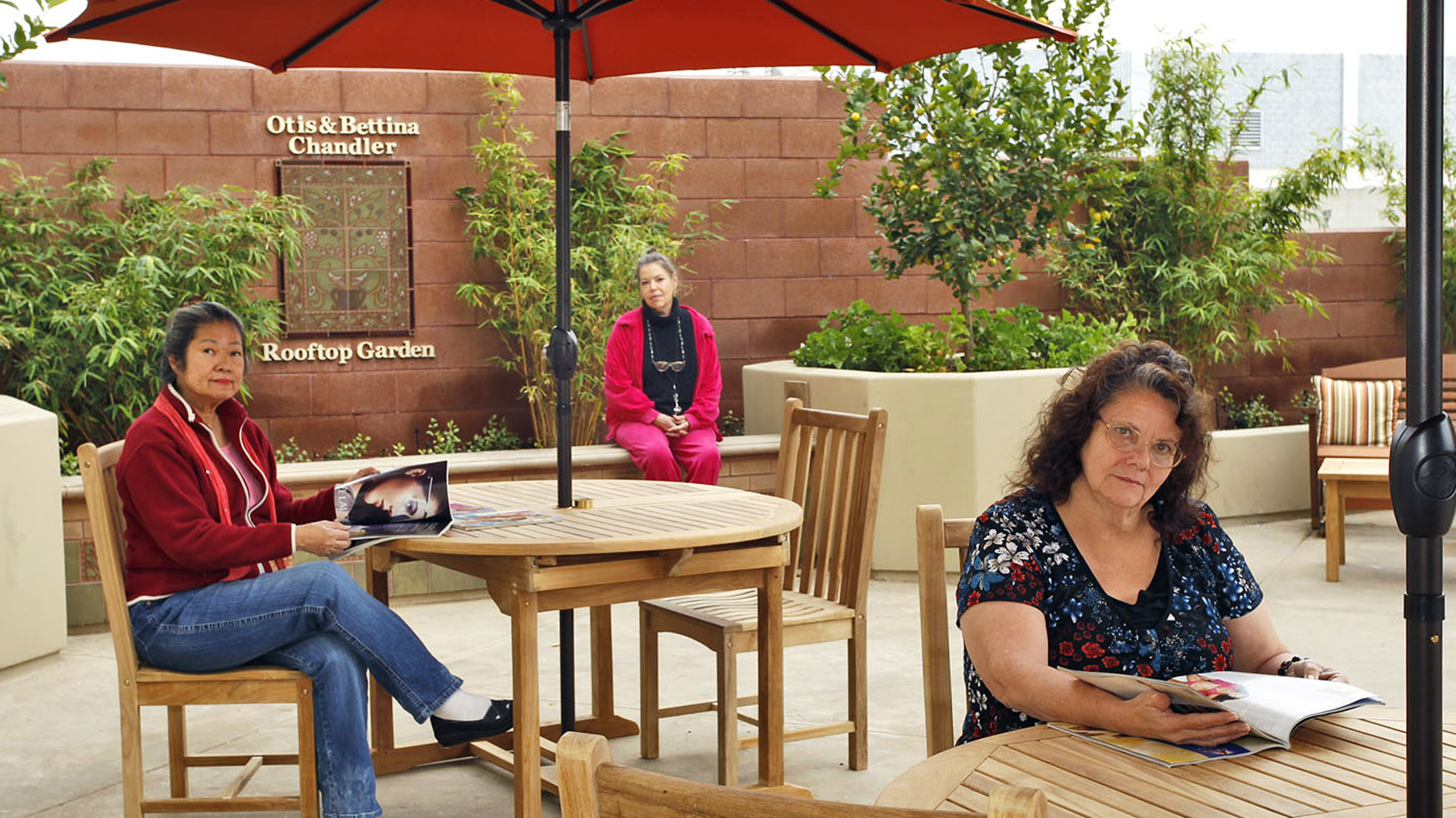 Women sit and read in a rooftop garden at the Downtown Women's Center in Los Angeles, a Pica+Sullivan Southern California non-profit architectural renovation project.