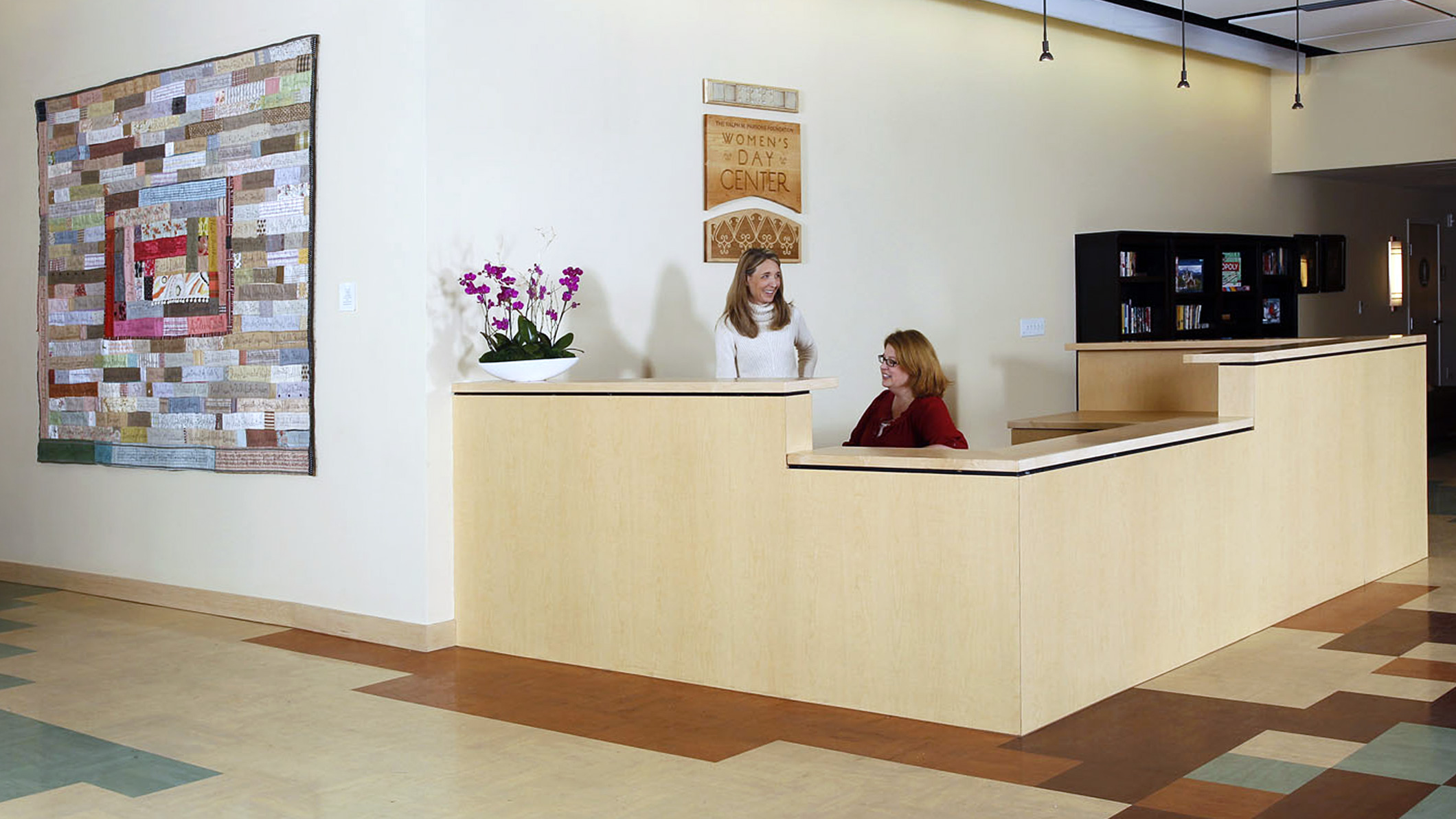 Two women talk in a reception area at the Downtown Women's Center in Los Angeles, a Pica+Sullivan Southern California non-profit architectural renovation project.