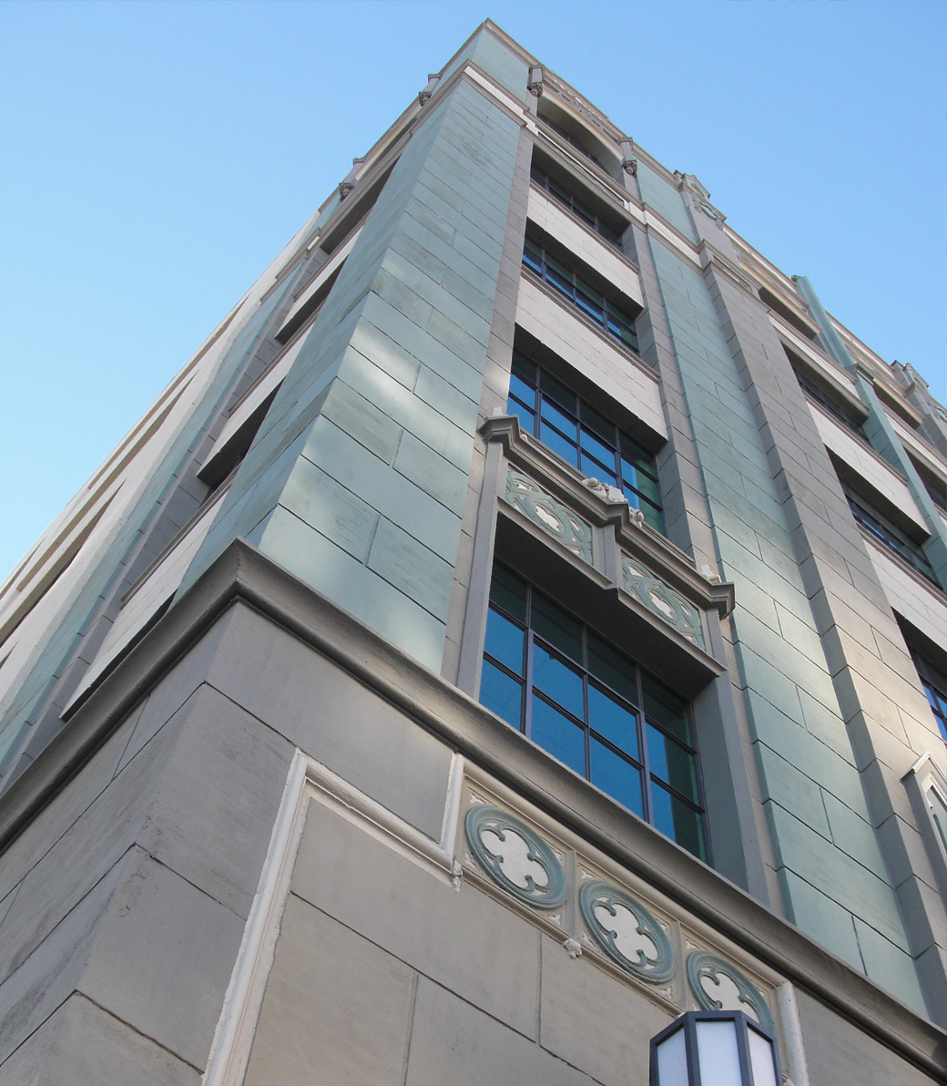 Exterior of the Downtown Women's Center in Los Angeles, a Pica+Sullivan Southern California non-profit architectural renovation project, from a low angle, focusing on the windows and decorative features.
