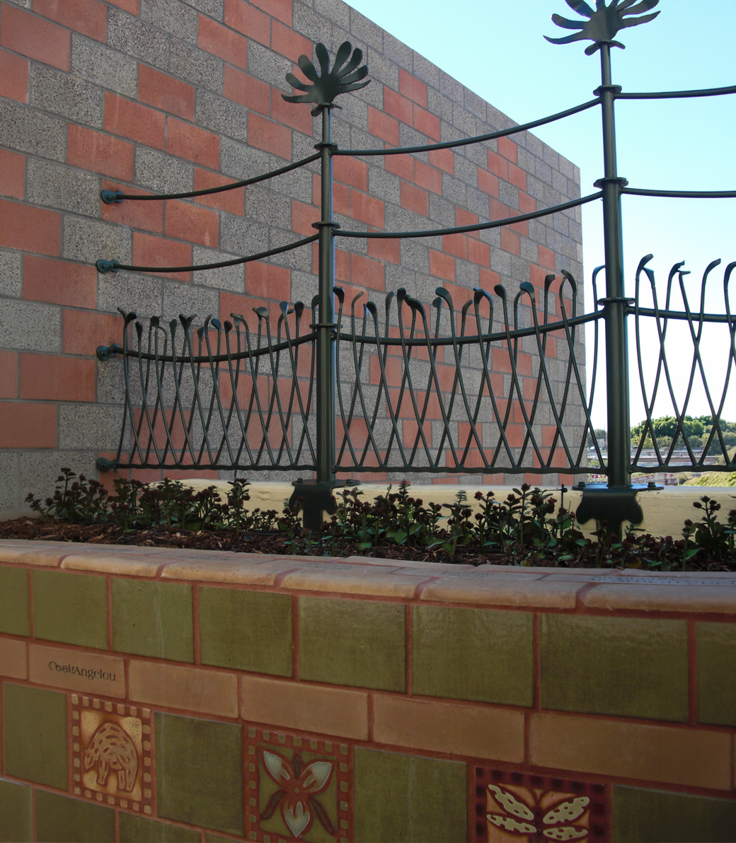 A low wall with decorative elements and decorative metal safety fencing on top of it at the Downtown Women's Center in Los Angeles, a Pica+Sullivan Southern California non-profit architectural renovation project.