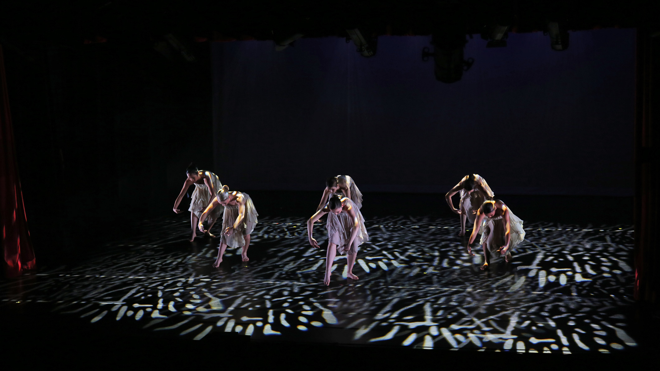 Female students dance ballet on stage at the Mozilo Family Center for the Arts at the Flintridge Sacred Arts Academy, an educational architectural project in Southern California.