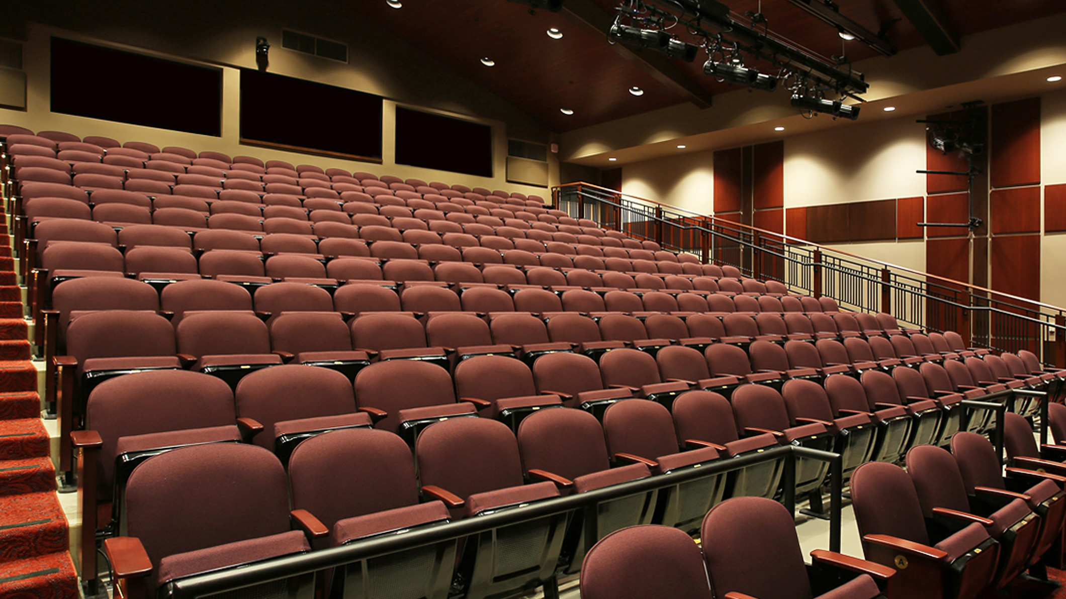 View of rows of seats from the floor in an auditorium at the Mozilo Family Center for the Arts at the Flintridge Sacred Arts Academy, an educational architectural project in Southern California.