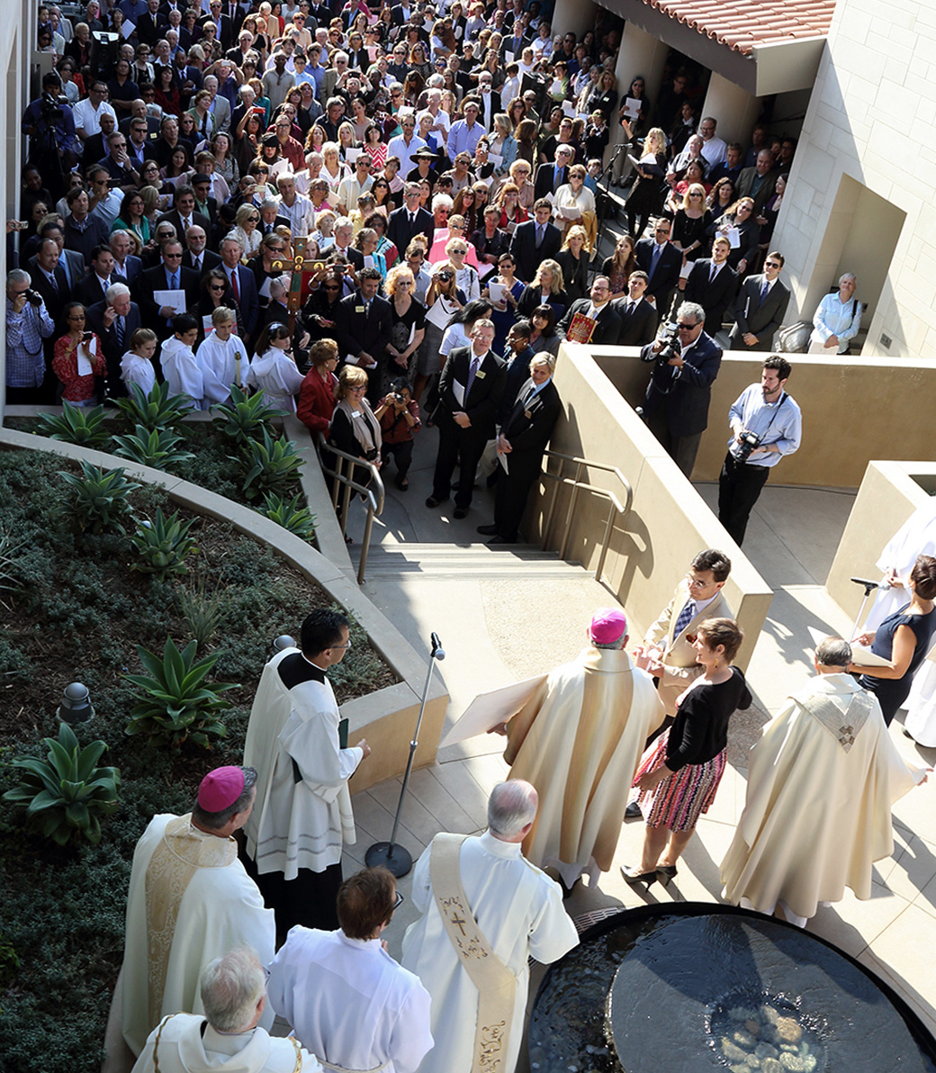 A large crowd attends a ceremony officiated by Catholic clergy with Joe Pica and Maureen Sullivan at the Saint Monica Community Center in Santa Monica, a Southern California religious and educational architectural project.