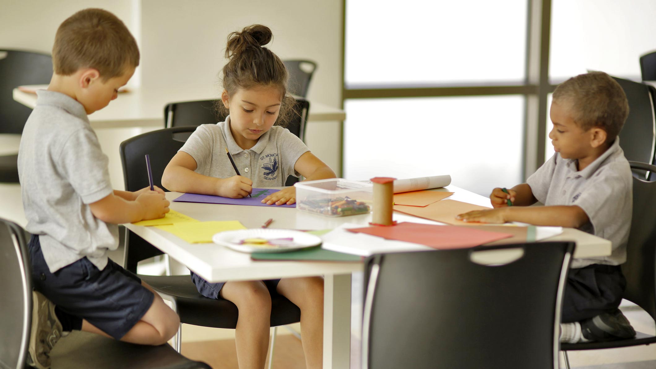 Students draw on construction paper at the Saint Monica Community Center in Santa Monica, a Southern California religious and educational architectural project.