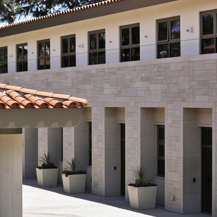Exterior of the Saint Monica Community Center in Santa Monica, a Pica+Sullivan Southern California educational and religious architectural project, showcasing the design work, second-floor windows, and rooftops.