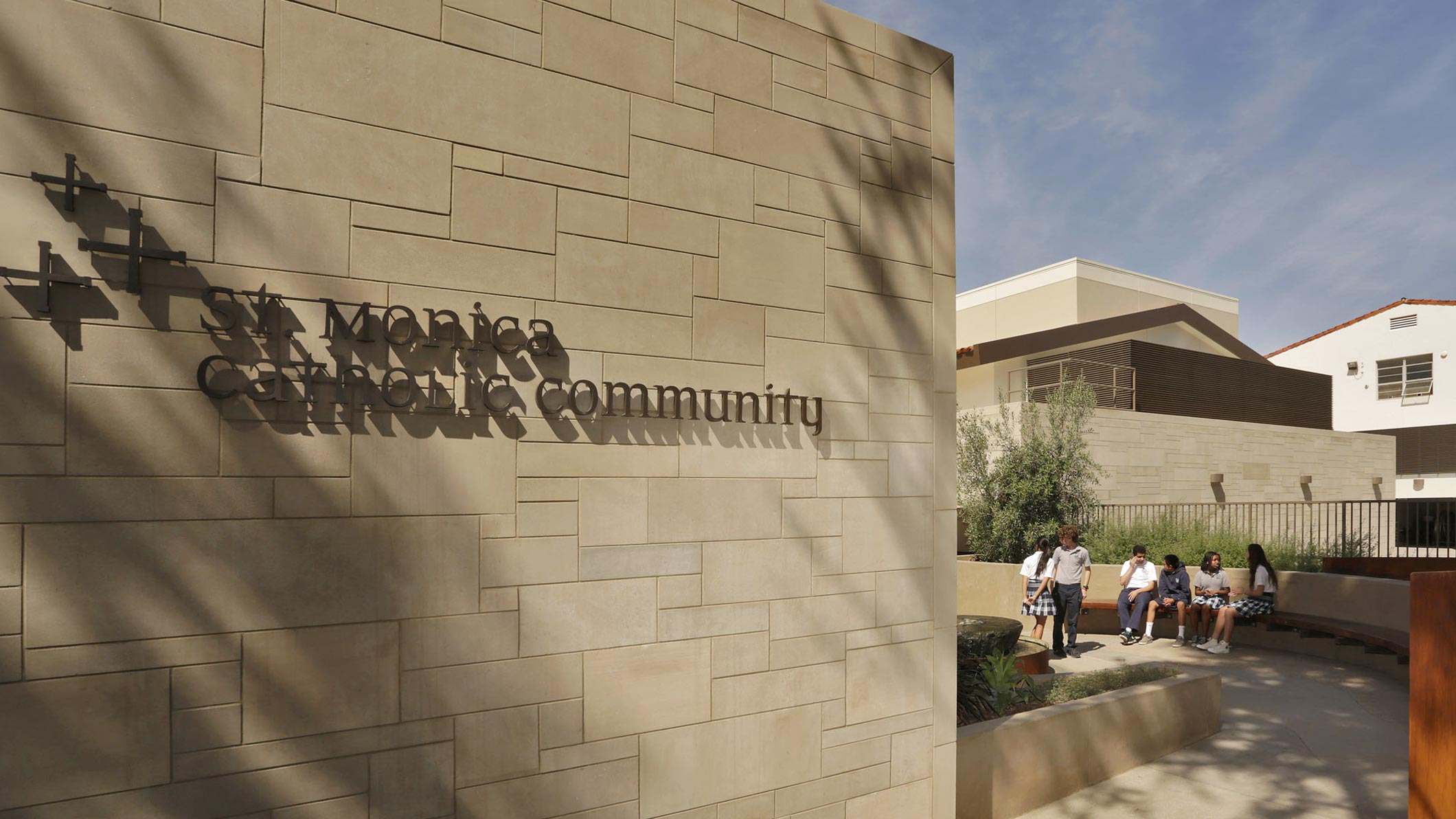 The exterior wall of the Saint Monica Community Center in Santa Monica, a Southern California educational and religious architectural project. The words