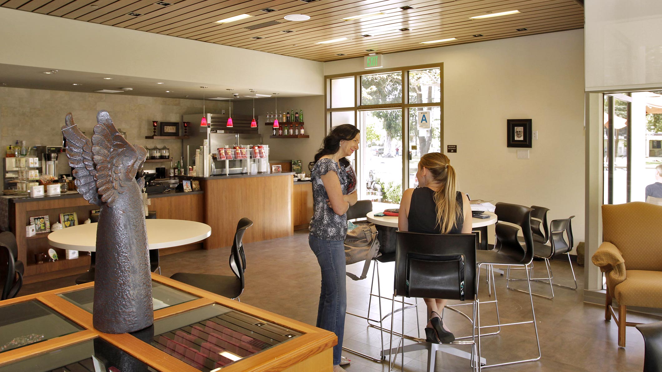 Two women talk in a coffee and community room at the Saint Monica Community Center in Santa Monica, a Southern California religious architectural project.
