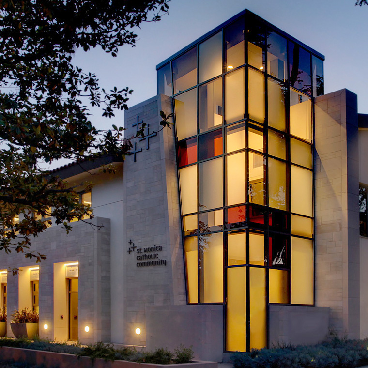 Nighttime exterior of a stunning glass-windowed tower at the Saint Monica Community Center in Santa Monica, a Pica+Sullivan Southern California educational and religious architectural project.