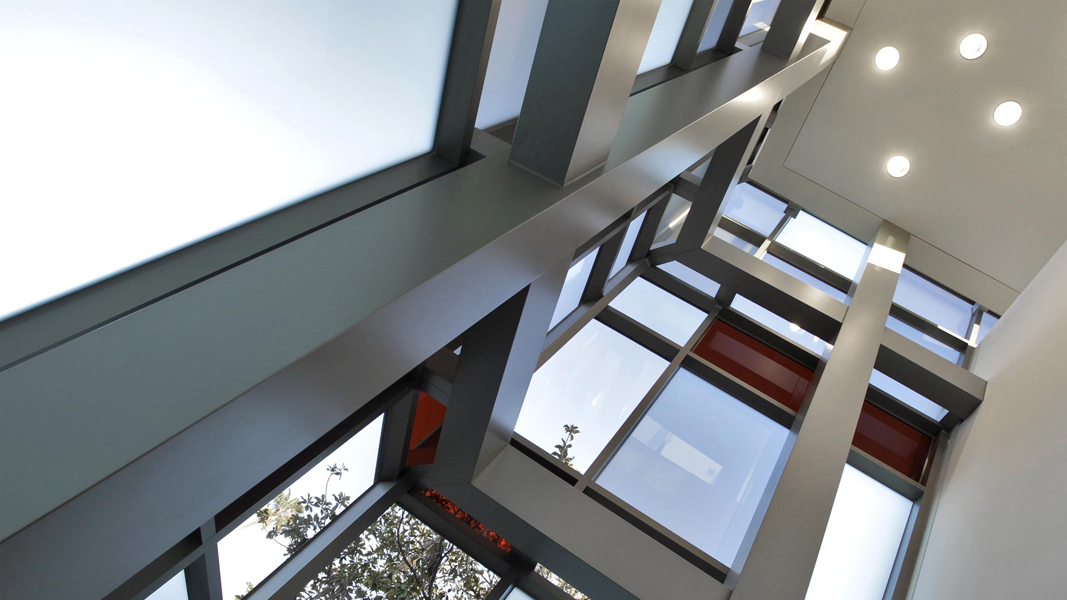 A low-angle ground-floor view of the corner walls, made up of windows, at the Saint Monica Community Center in Santa Monica, a Southern California religious and educational architectural project.