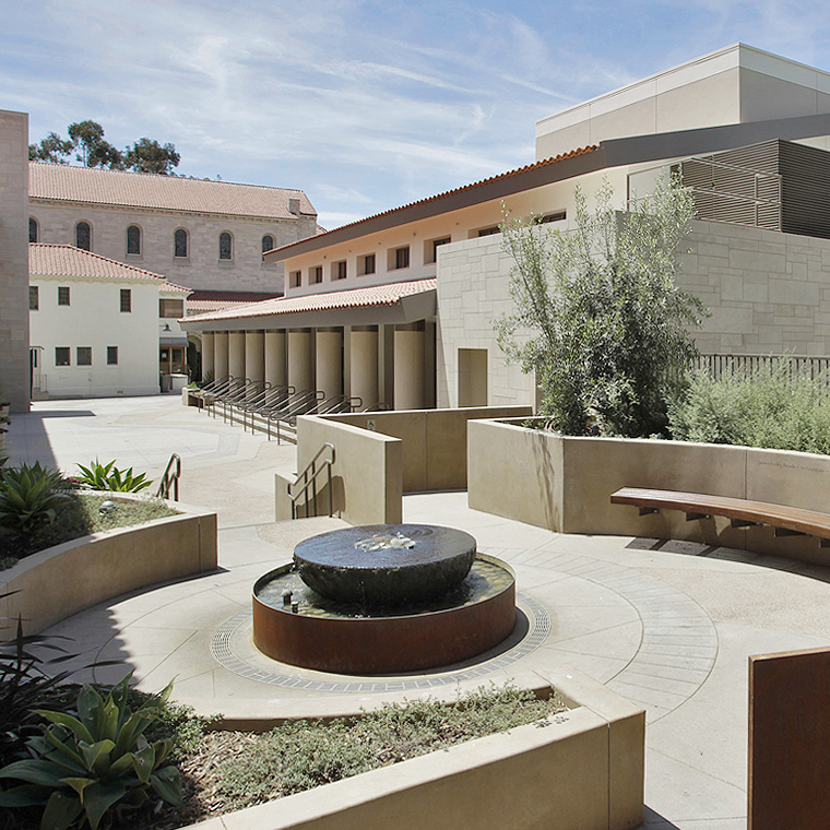 Exterior of a plaza area with benches and a fountain at the Saint Monica Community Center in Santa Monica, a Pica+Sullivan Southern California educational and religious architectural project.