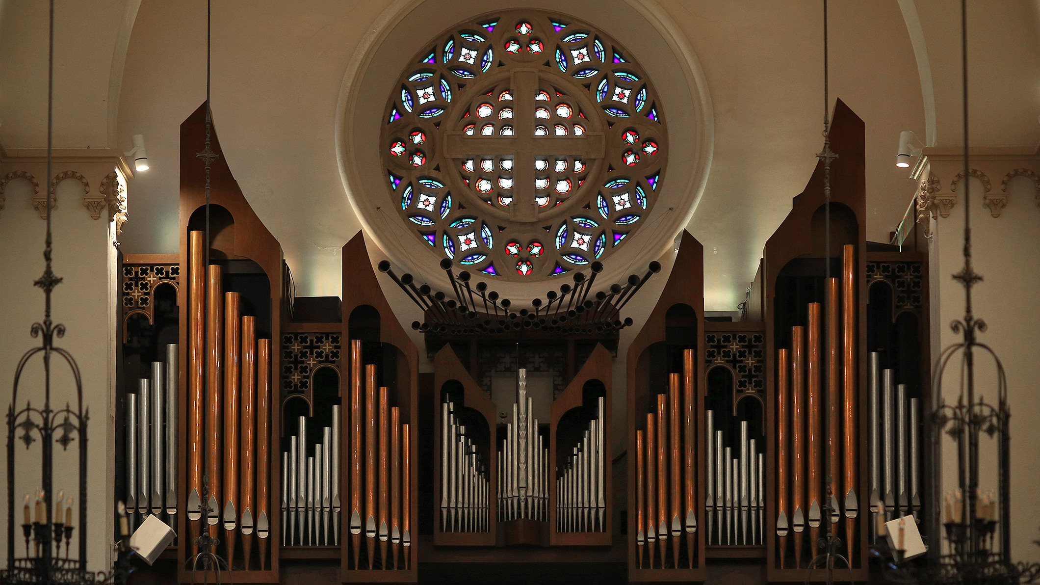 The pipe organ and stained glass window at Saint Monica Church in Santa Monica, a Pica+Sullivan Southern California religious architectural renovation project.
