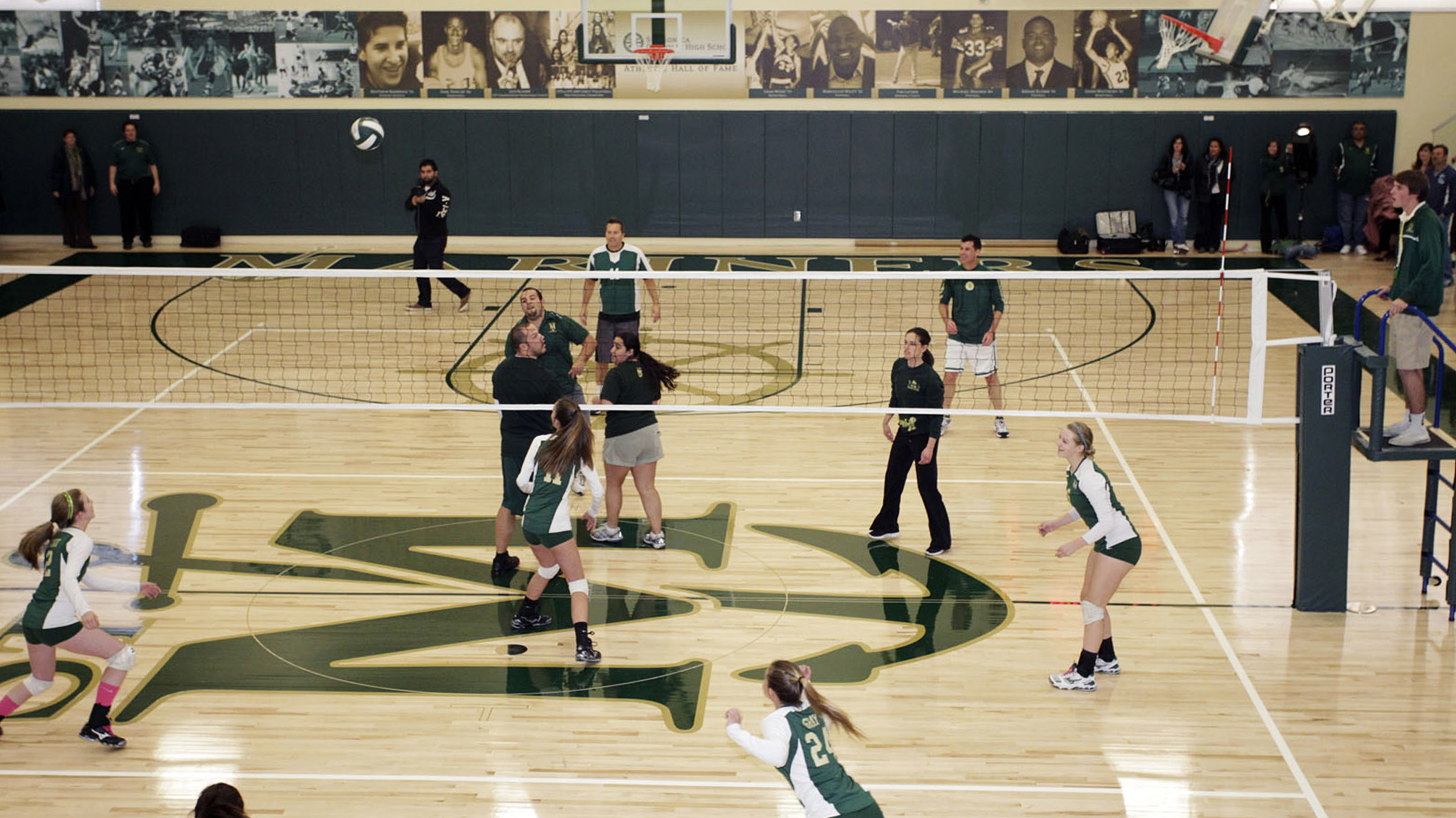 Students play volleyball in the Saint Monica Gymnasium, an educational architecture project.