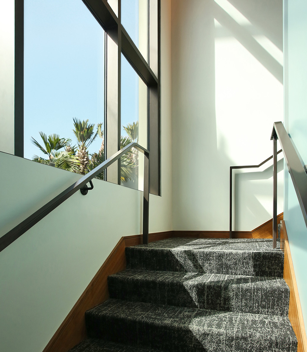 Light flows through large windows over an interior staircase at the the Holy Family Church Parish Center in Glendale, a Pica+Sullivan Southern California religious architectural project.