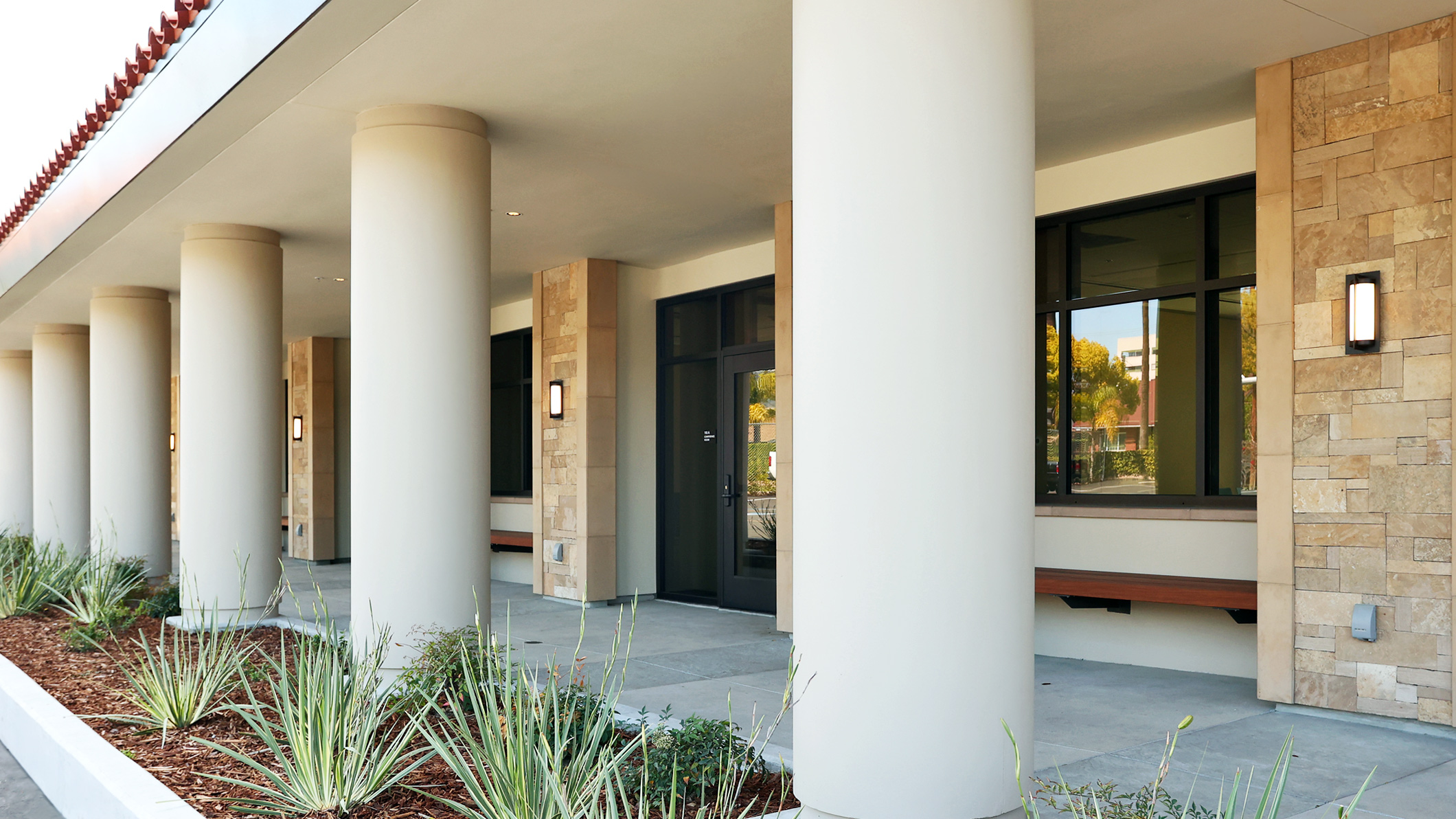Exterior of the Holy Family Church Parish Center in Glendale, a Pica+Sullivan Southern California religious architectural project, with a focus on the columns and porch overhang.