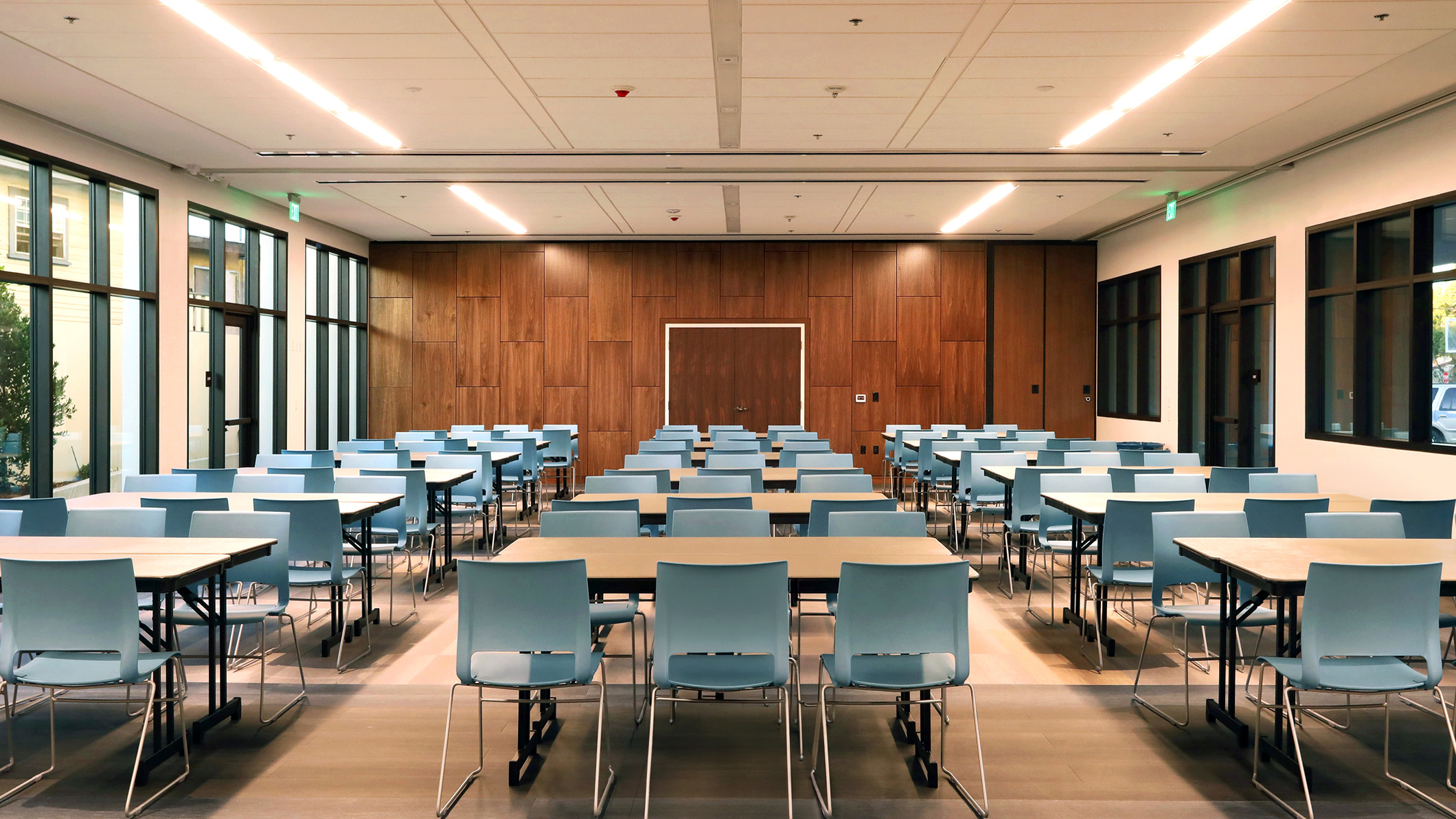 Empty room with tables and chairs in the Holy Family Church Parish Center in Glendale, a Pica+Sullivan Southern California religious architectural project.