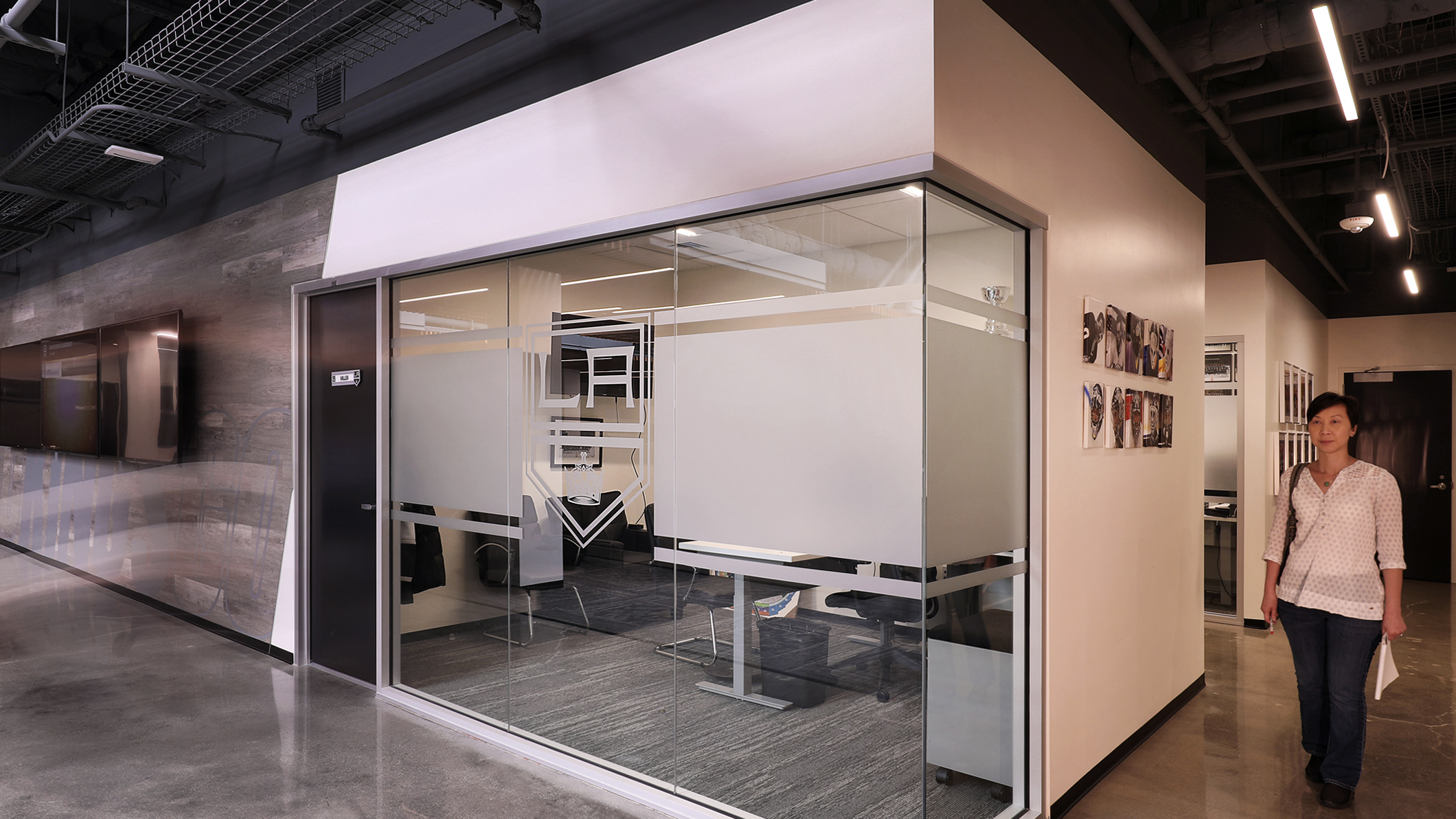 A woman walks around a corner at the LA Kings Business Office in El Segundo, a Pica+Sullivan Southern California architectural project.