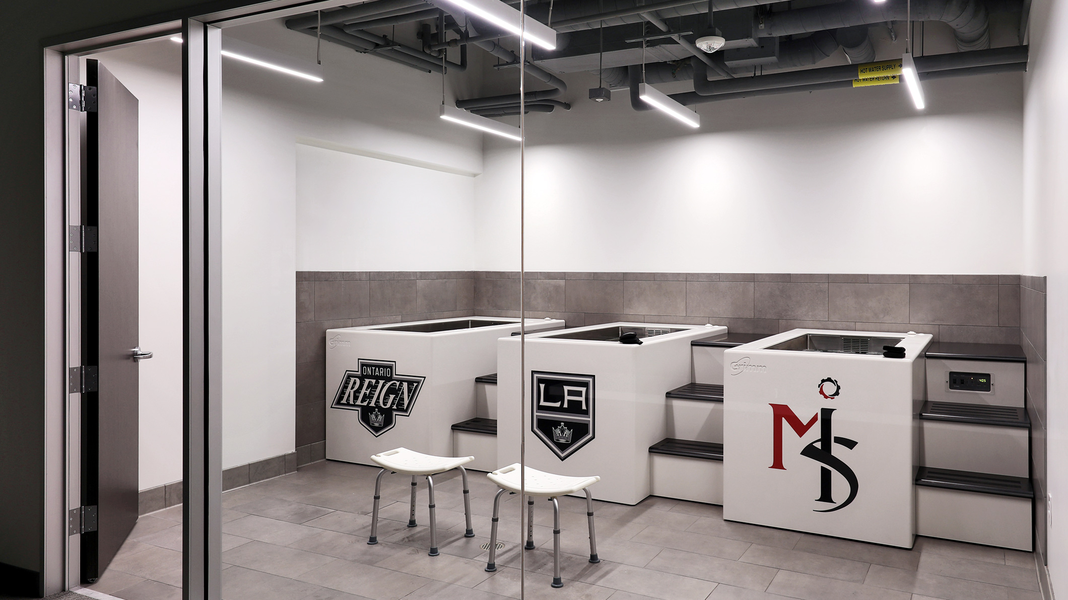 An empty rehabilitation room with open tubs at the LA Kings USC Meyer Sports Rehabilitation Center in El Segundo, a Pica+Sullivan Southern California architectural renovation project.