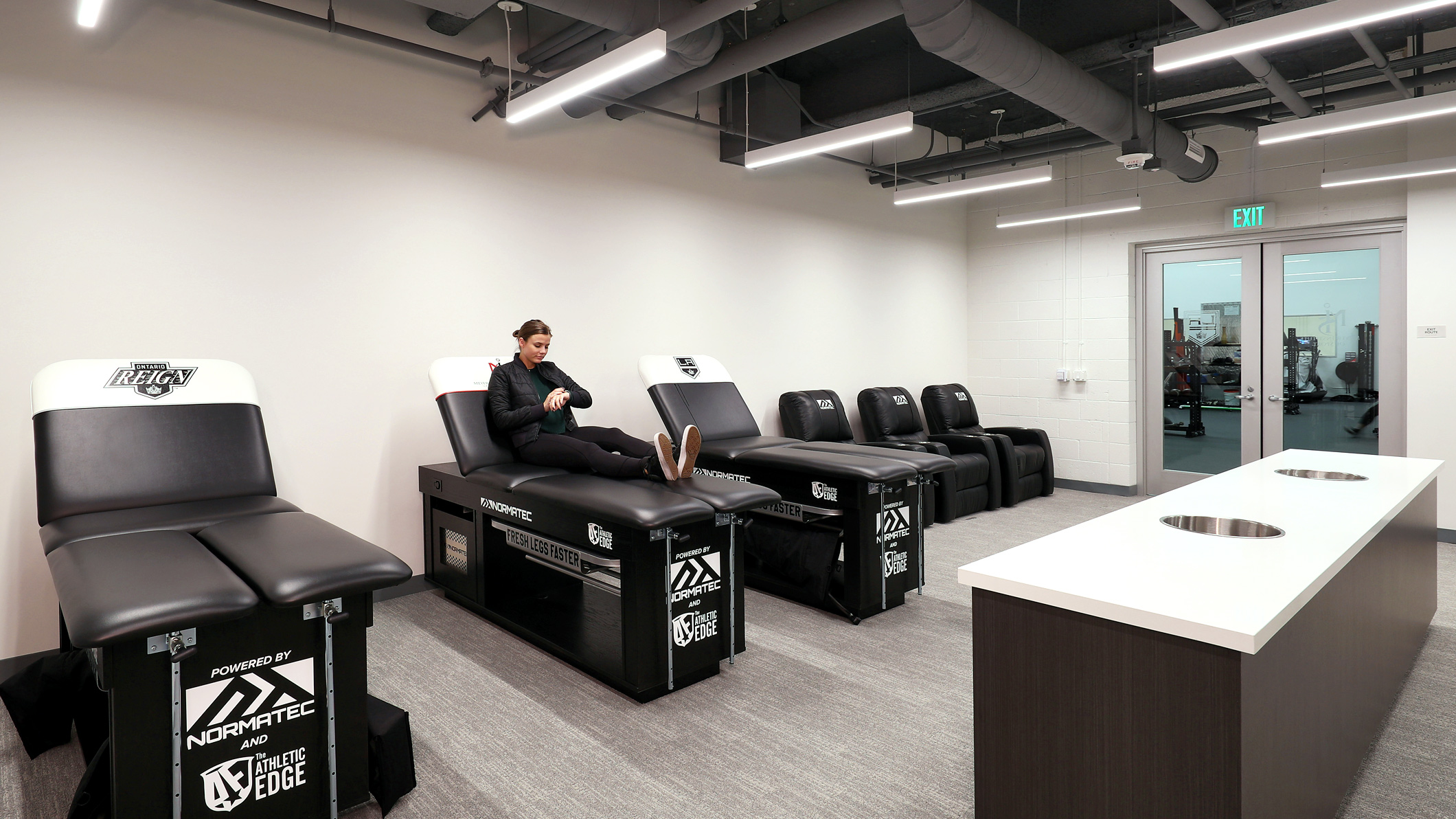LA-KINGS-USC-008 A woman sits on a massage table in a rehabilitation room at the LA Kings USC Meyer Sports Rehabilitation Center in El Segundo, a Pica+Sullivan Southern California architectural renovation project.