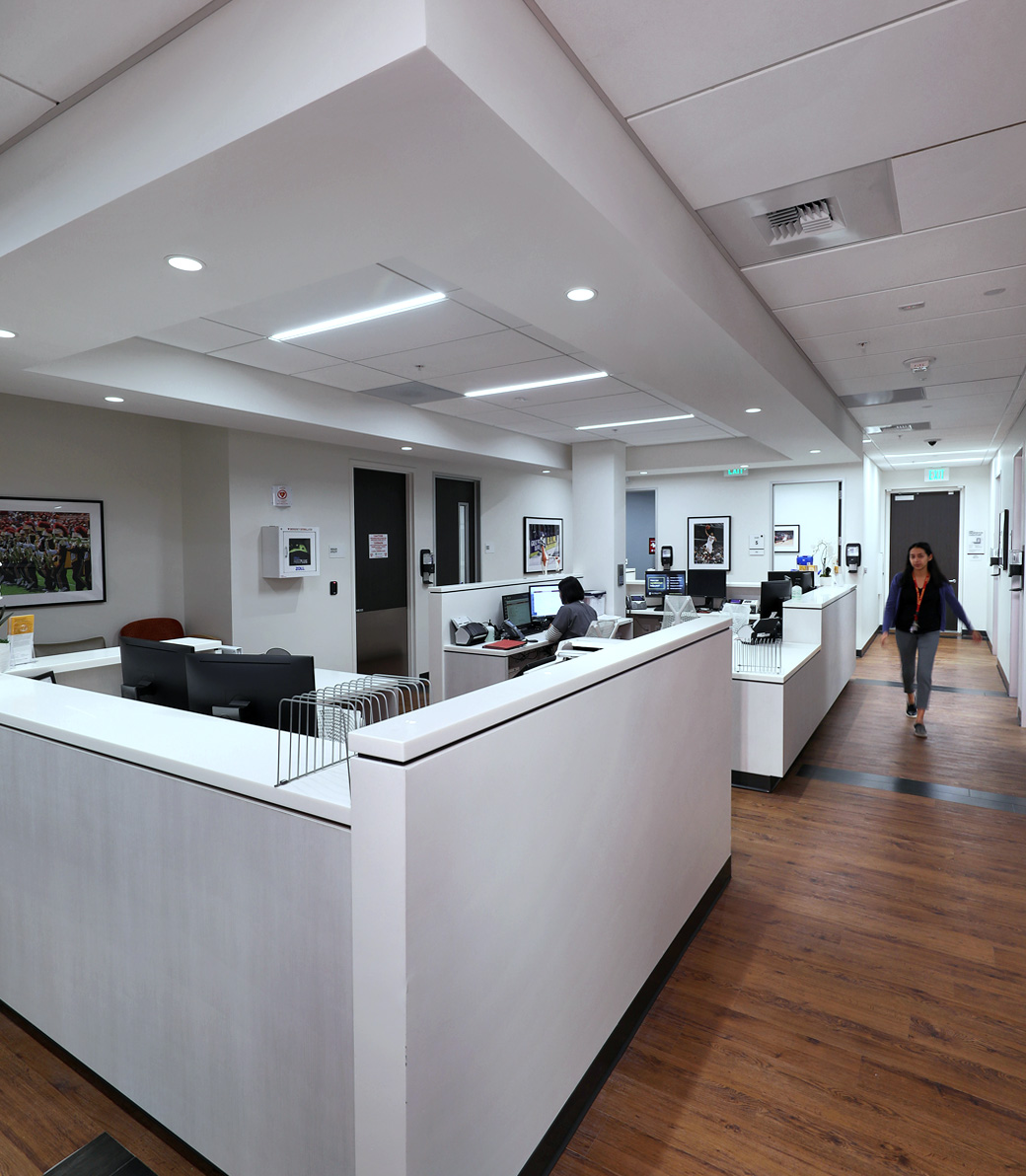 LA-KINGS-USC-015 Staff sit at desks and walk the halls in a central area at the LA Kings USC Meyer Sports Rehabilitation Center in El Segundo, a Pica+Sullivan Southern California architectural renovation project.