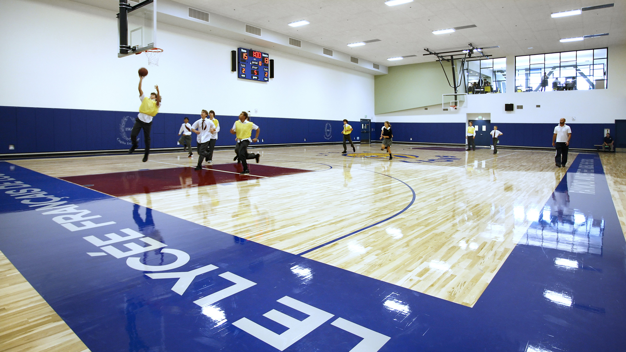 Students play basketball in an indoor basketball court at Le Français de Los Angeles in Los Angeles, a Pica+Sullivan Southern California educational architectural project.
