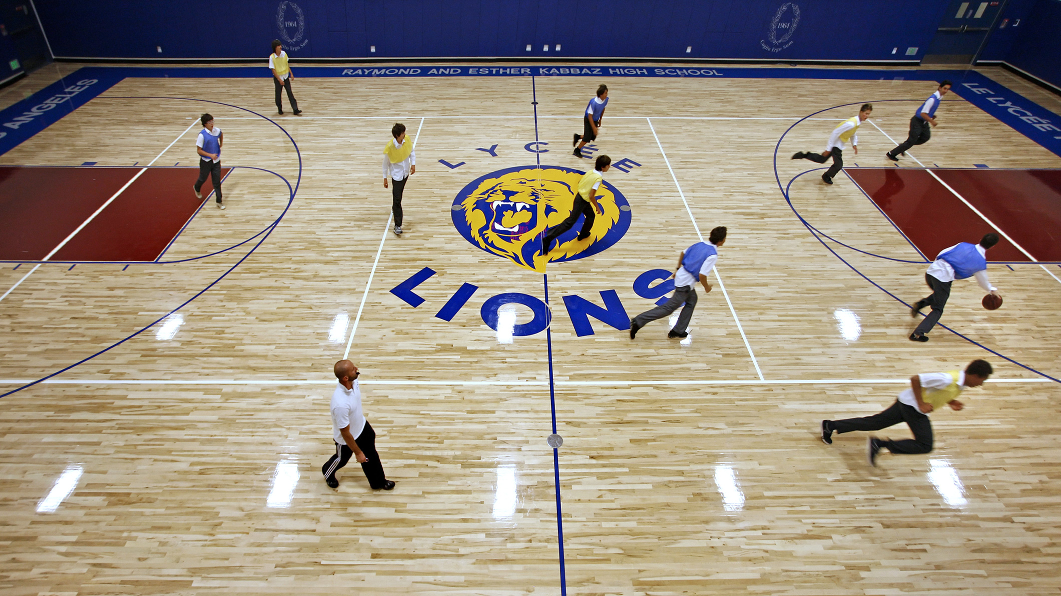 Students play basketball in an indoor basketball court at Le Français de Los Angeles in Los Angeles, a Pica+Sullivan Southern California educational architectural project.