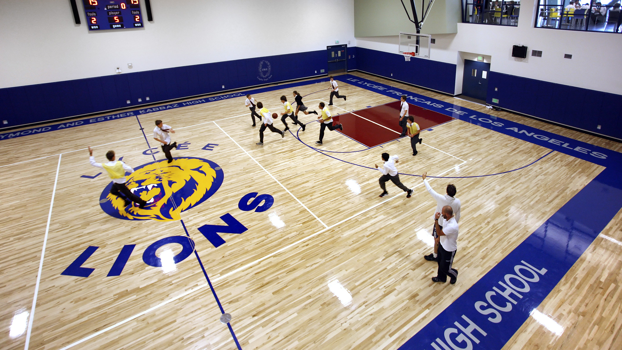 Students play basketball in an indoor basketball court at Le Français de Los Angeles in Los Angeles, a Pica+Sullivan Southern California educational architectural project.