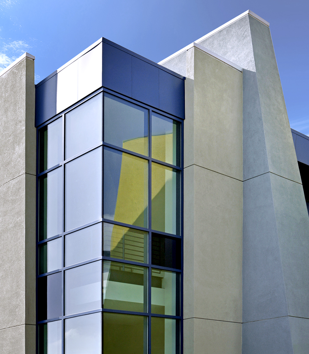 Exterior of Le Lycée Français de Los Angeles in Los Angeles, a Pica+Sullivan Southern California educational architectural project, as photographed from the ground at a low angle, with a focus on the decorative wall of windows.