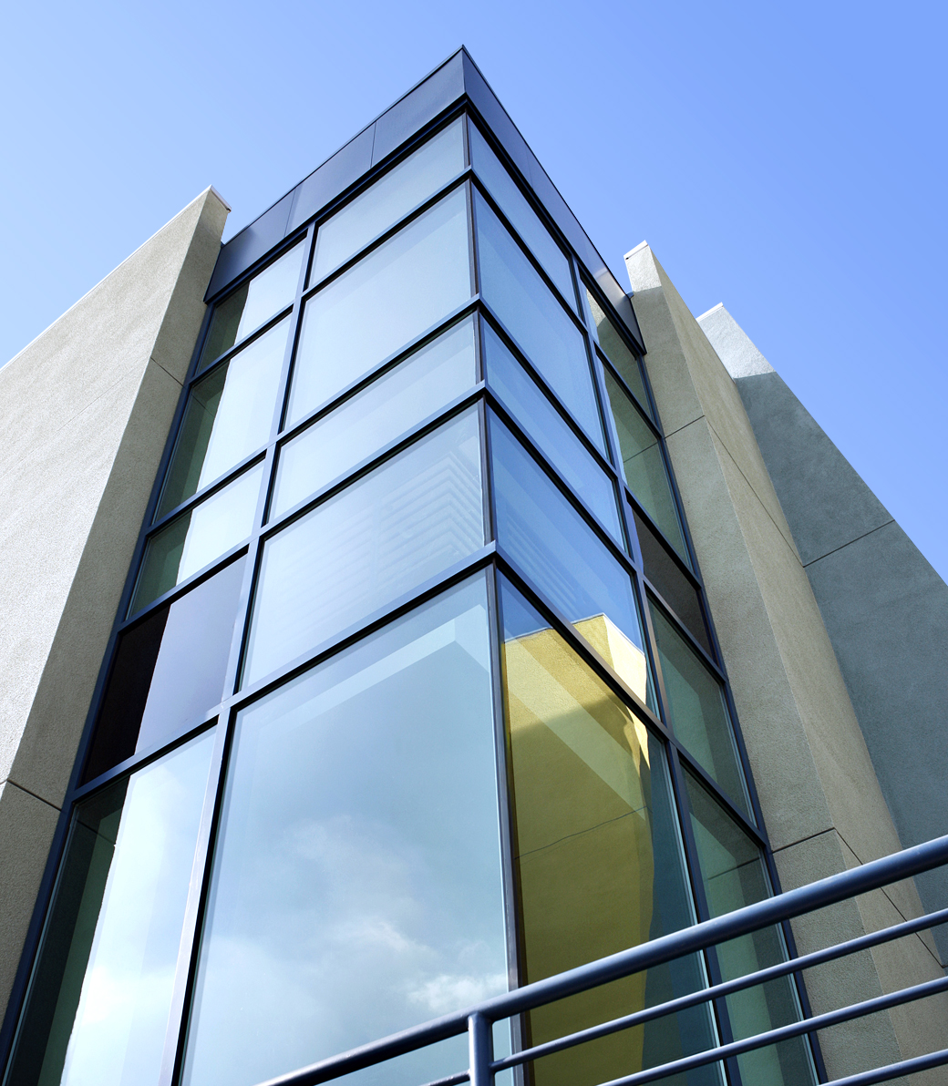 Exterior of Le Lycée Français de Los Angeles in Los Angeles, a Pica+Sullivan Southern California educational architectural project, as photographed from the ground at a low angle, with a focus on the decorative wall of windows.
