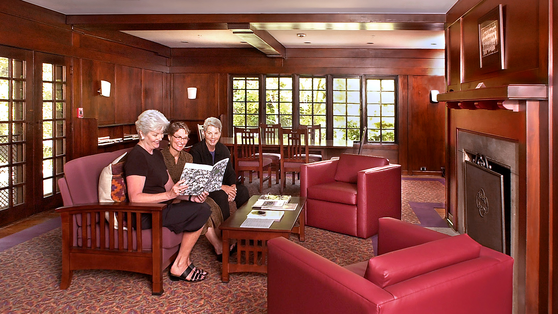 PITCAIRN_003 Three women look at a book in a study room in Pitcairn House in Pasadena, a Pica+Sullivan Southern California educational architectural renovation project.