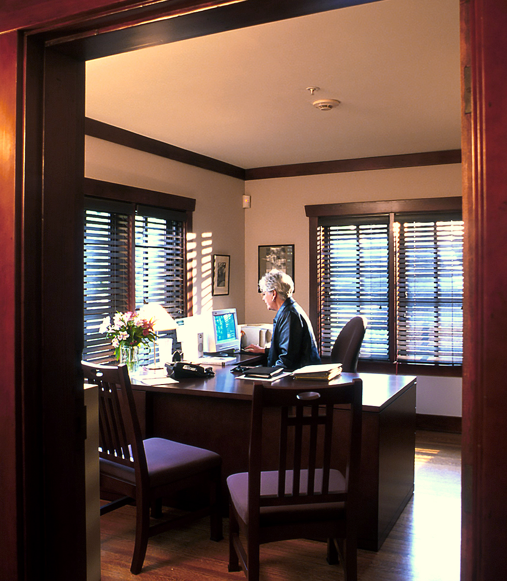 PITCAIRN_005 A woman sits at a desk working on a computer in an office in Pitcairn House in Pasadena, a Pica+Sullivan Southern California educational architectural renovation project.