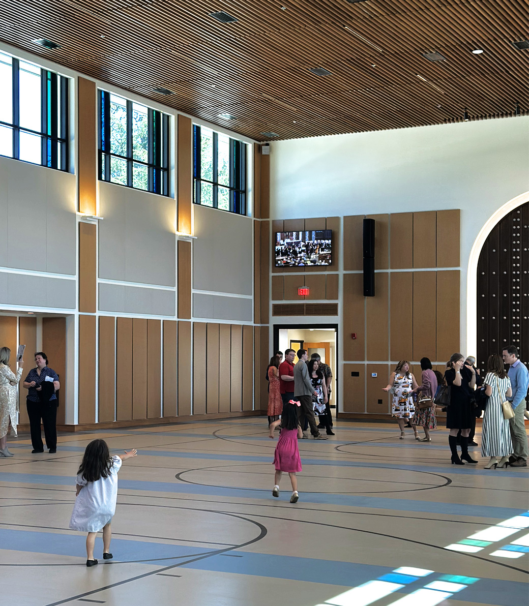 Parishioners mill on a basketball court at Saint Bede the Venerable Parish Hall in La Cañada Flintridge, a Pica+Sullivan Southern California religious and educational architectural project.