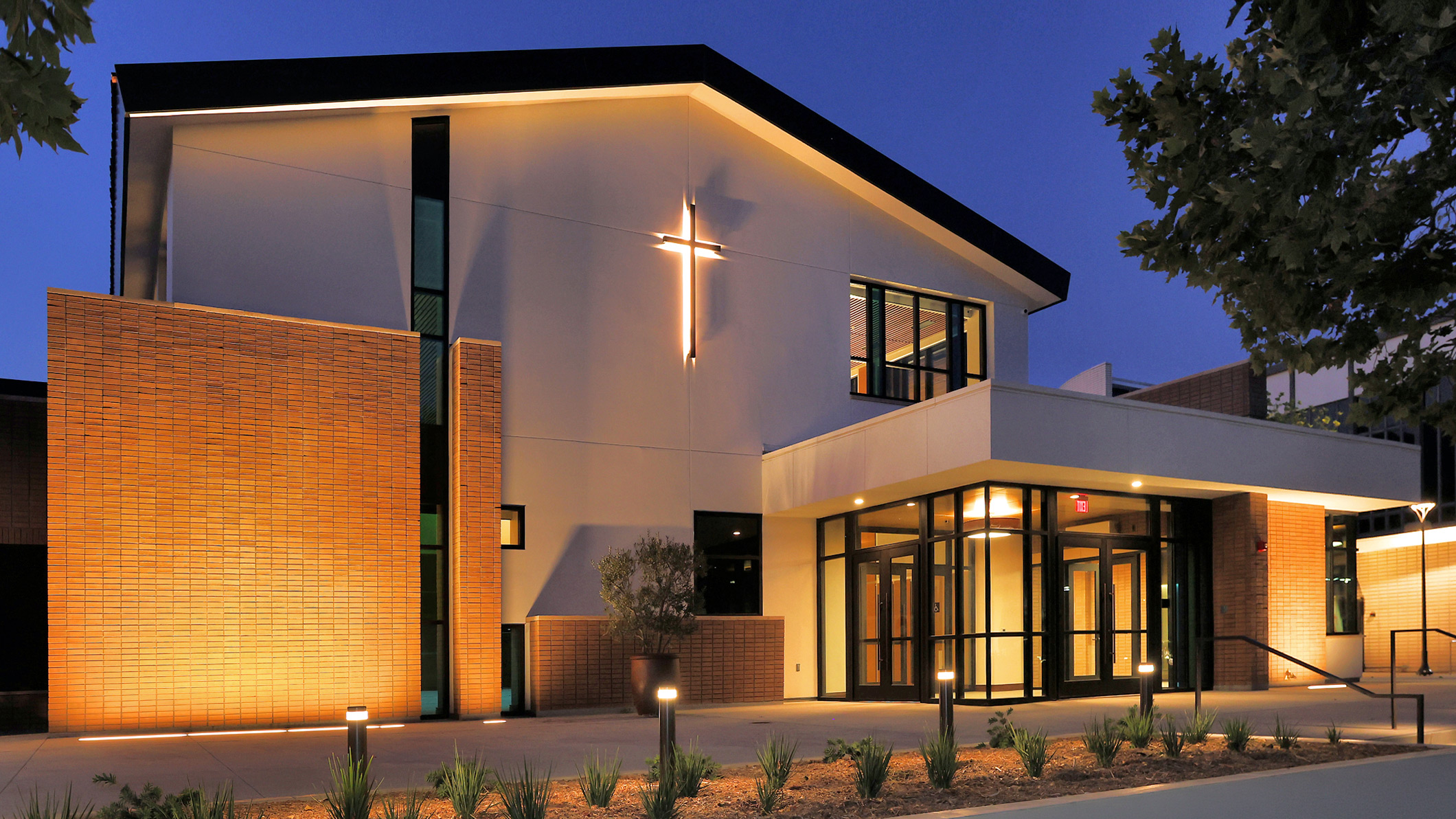Nighttime exterior of the front of Saint Bede the Venerable Parish Hall in La Cañada Flintridge, a Pica+Sullivan Southern California religious and educational architectural project.