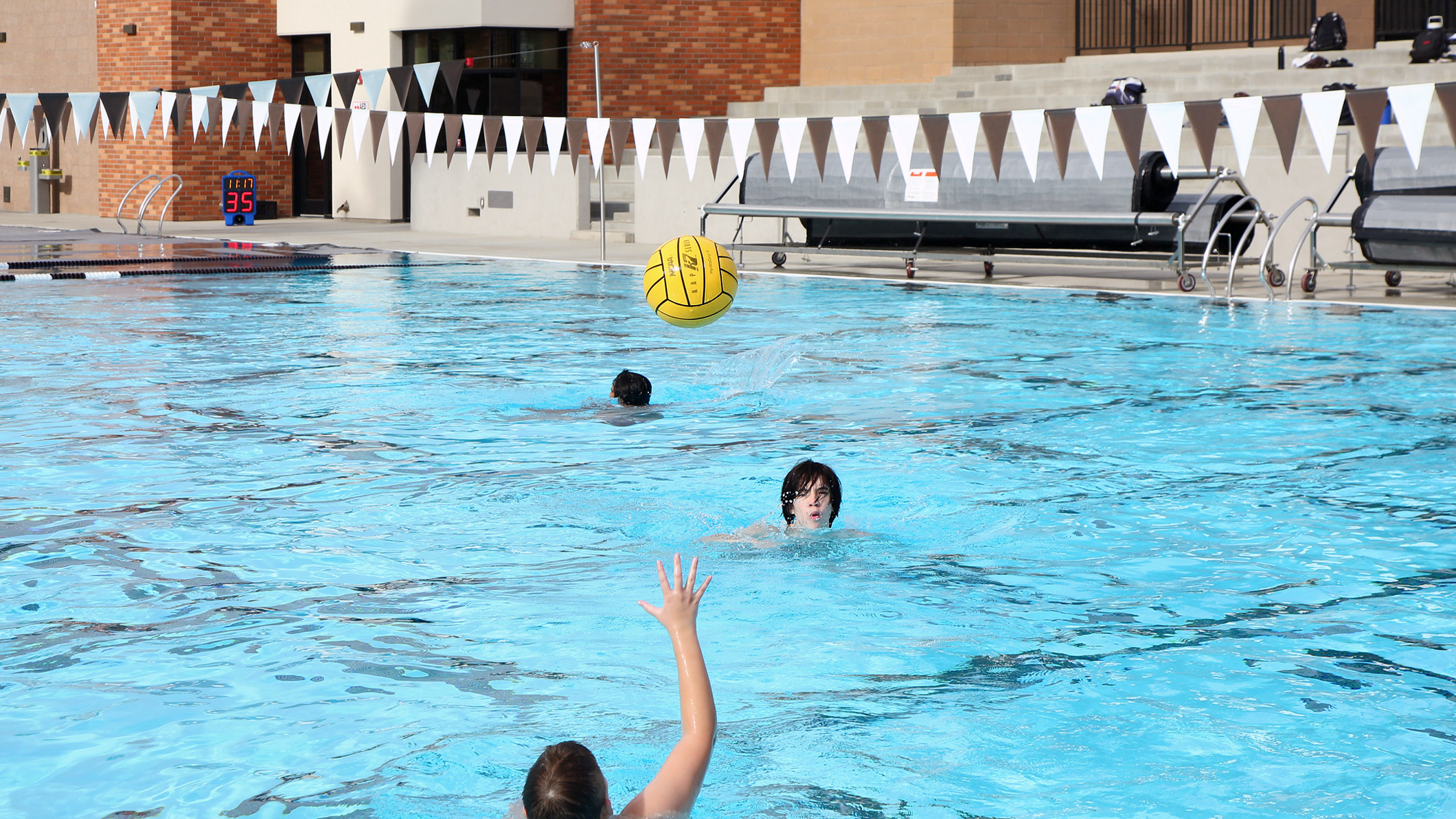 Students play with a water polo ball in the pool at the Robinson Family Aquatics Center at Crespi Carmelite High School in Encino, a Pica+Sullivan Southern California educational architectural project.