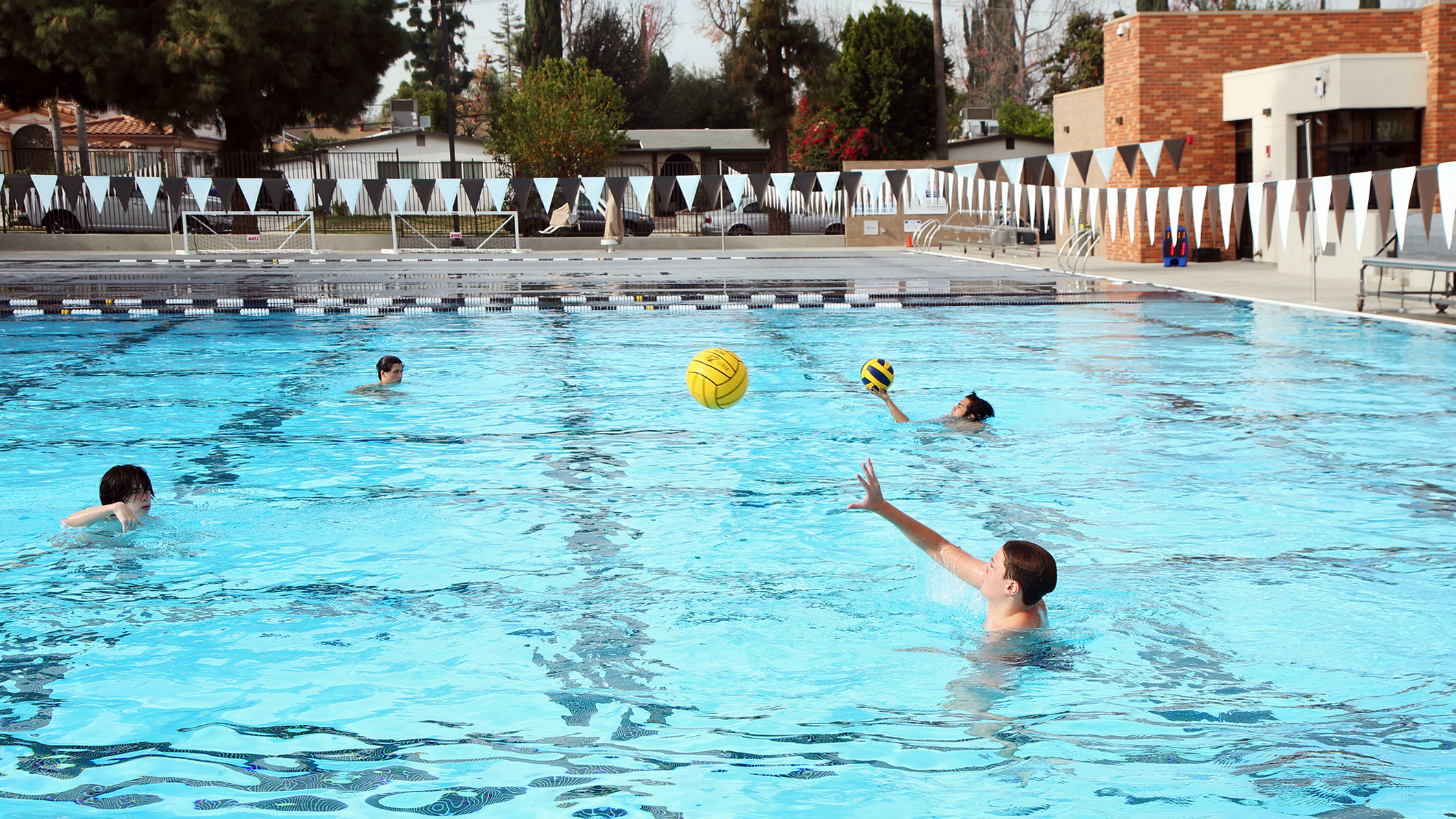 Students play with a water polo ball in the pool at the Robinson Family Aquatics Center at Crespi Carmelite High School in Encino, a Pica+Sullivan Southern California educational architectural project.