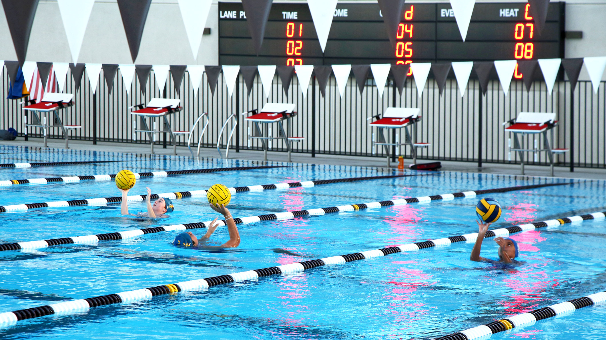 Students play with a water polo ball in the pool at the Robinson Family Aquatics Center at Crespi Carmelite High School in Encino, a Pica+Sullivan Southern California educational architectural project.
