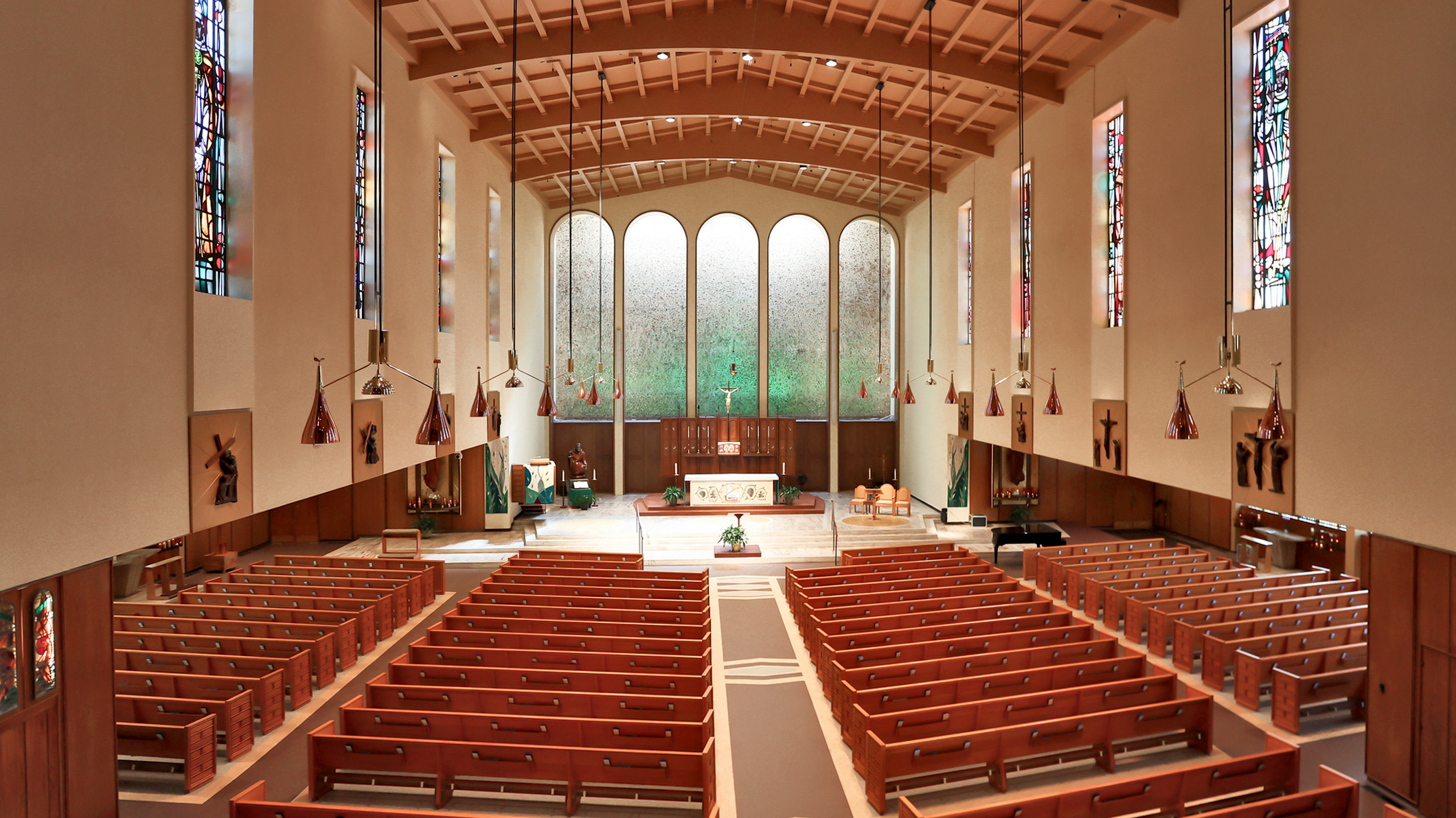 High-angle view of the empty interior of Saint Paul the Apostle Church in Los Angeles, a Pica+Sullivan Southern California religious architectural renovation project, facing the altar.